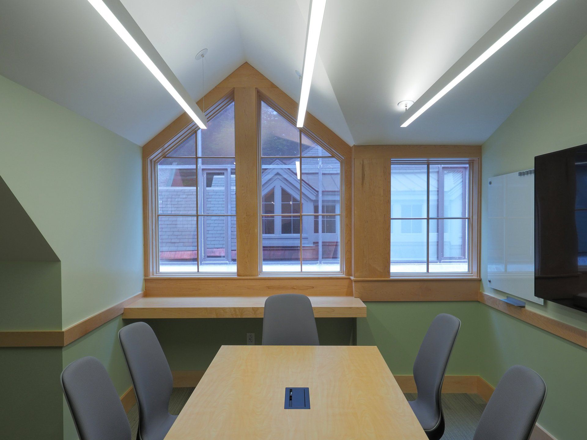 A conference room with a table and chairs and a large window