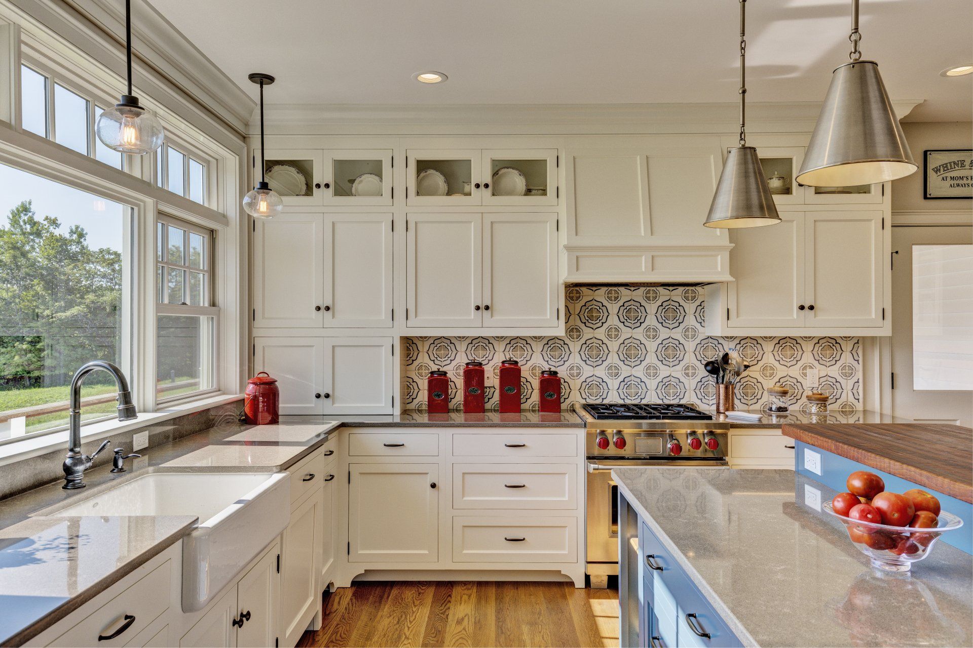 A kitchen with white cabinets , granite counter tops , a stove and a sink.