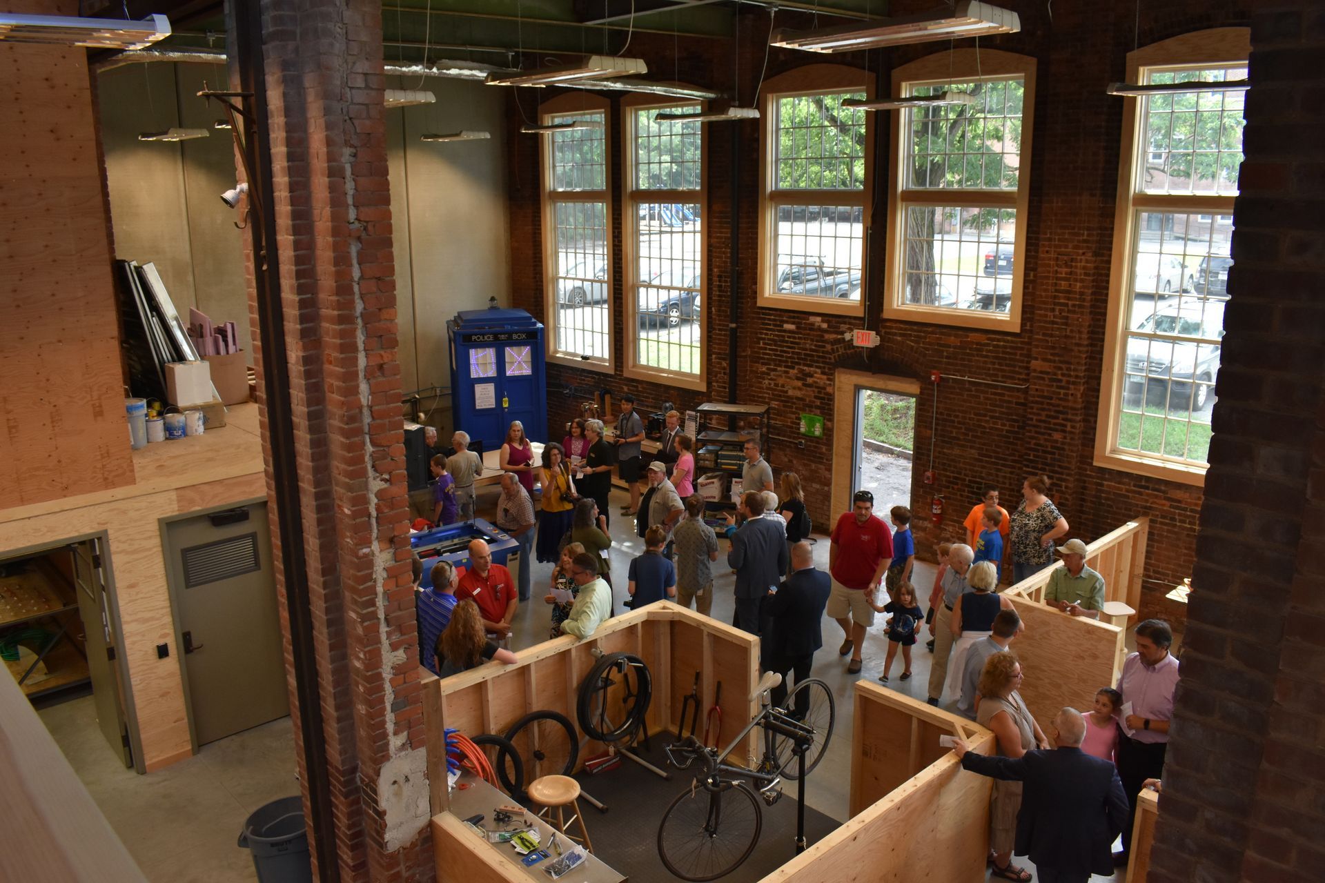 A group of people are standing in a room with a bicycle on the floor.