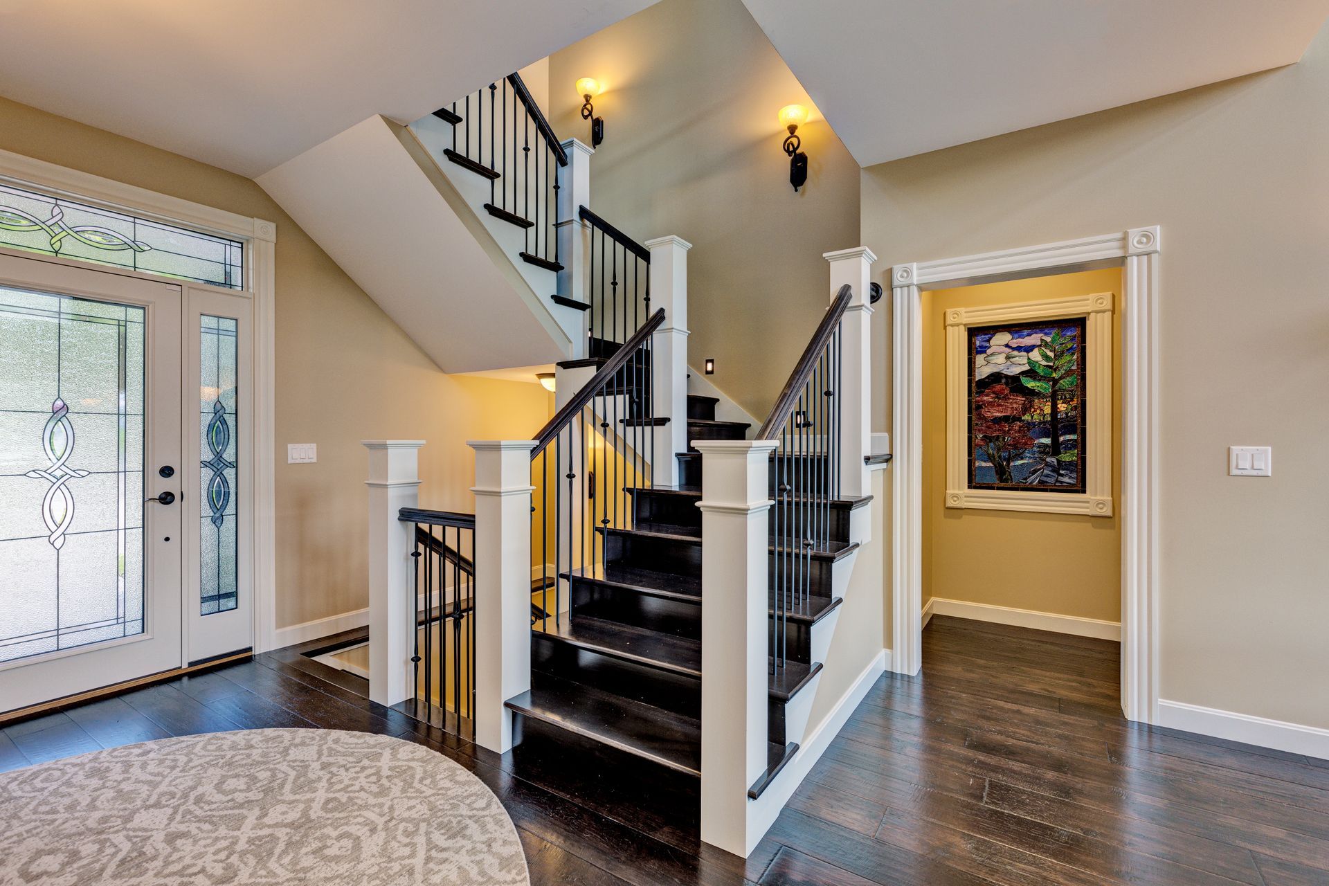 A hallway with stairs leading up to the second floor of a house.