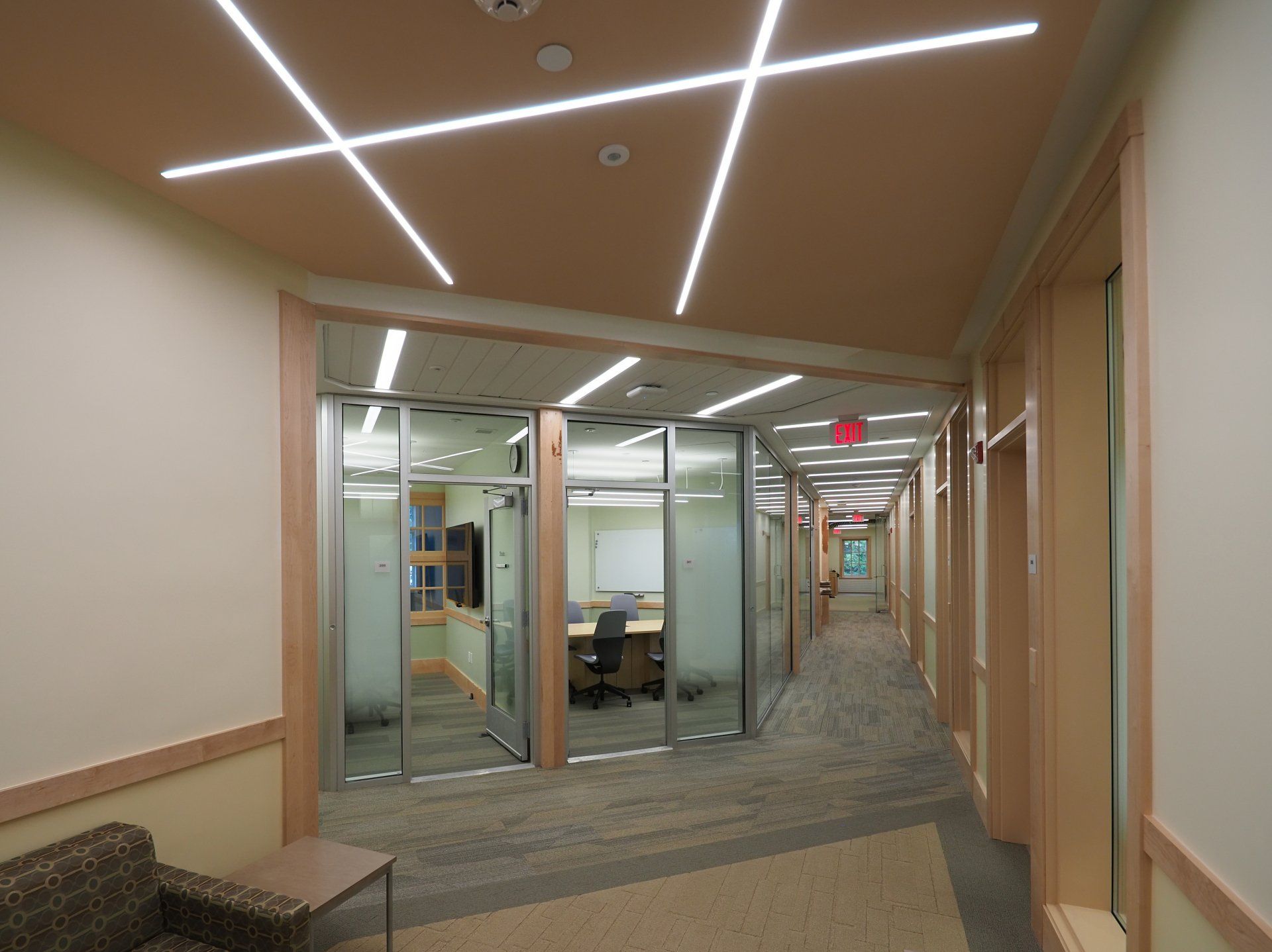 A long hallway with a red exit sign on the ceiling