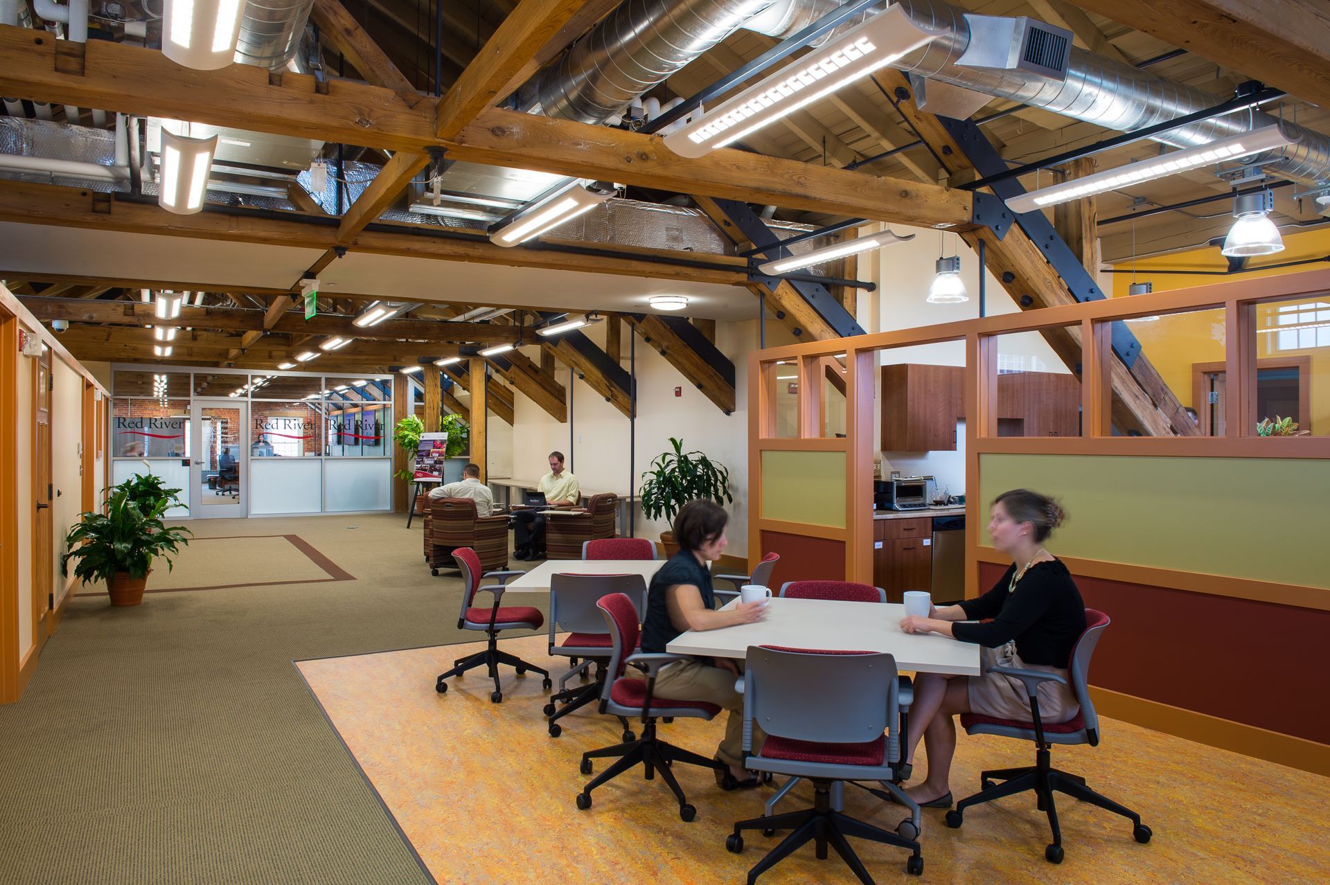 A group of people are sitting around a table in an office.