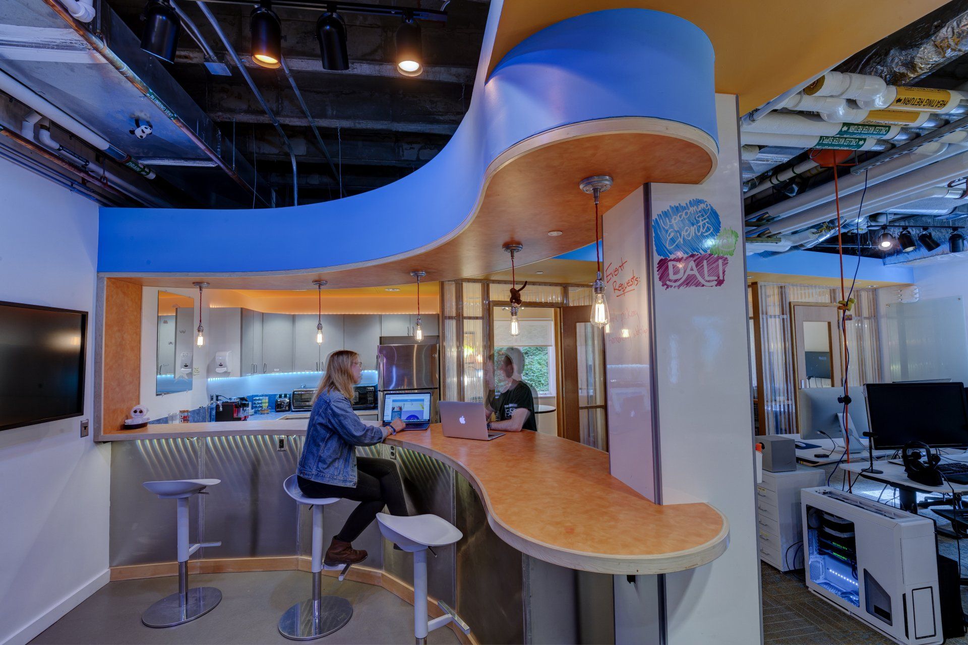 A man is sitting at a bar using a laptop computer.