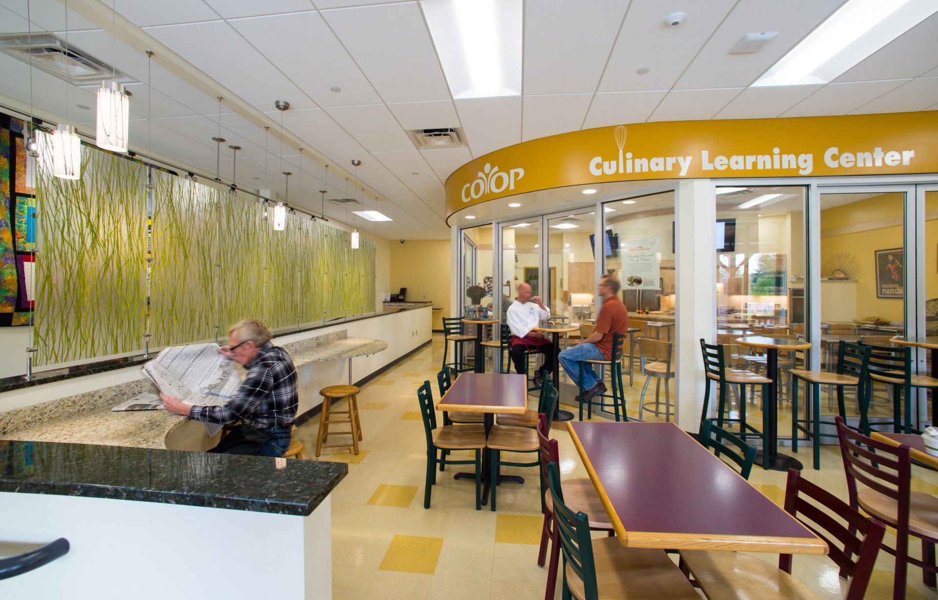 People are sitting at tables in a culinary learning center