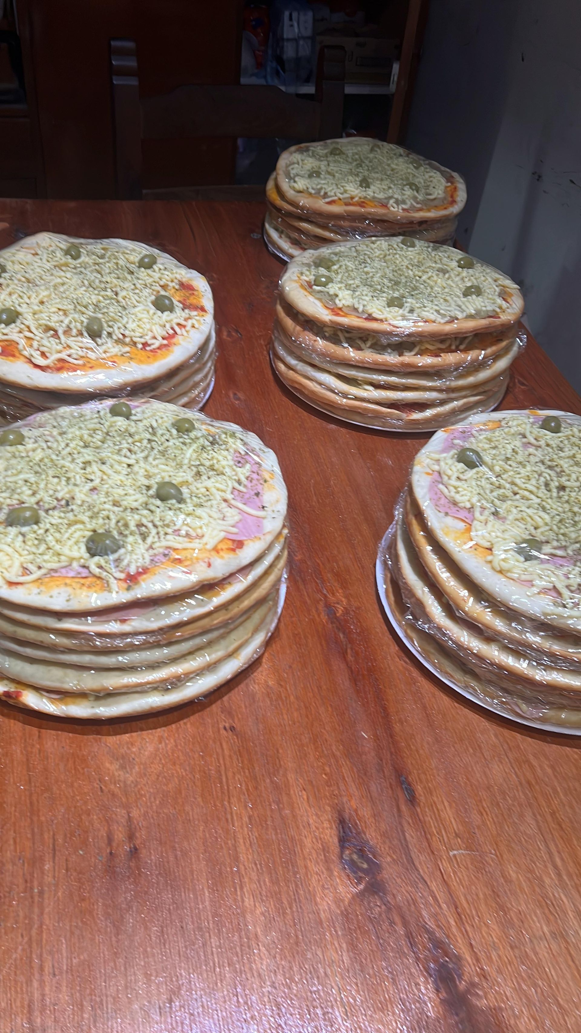 Una pila de pizzas colocadas una encima de otra sobre una mesa de madera.