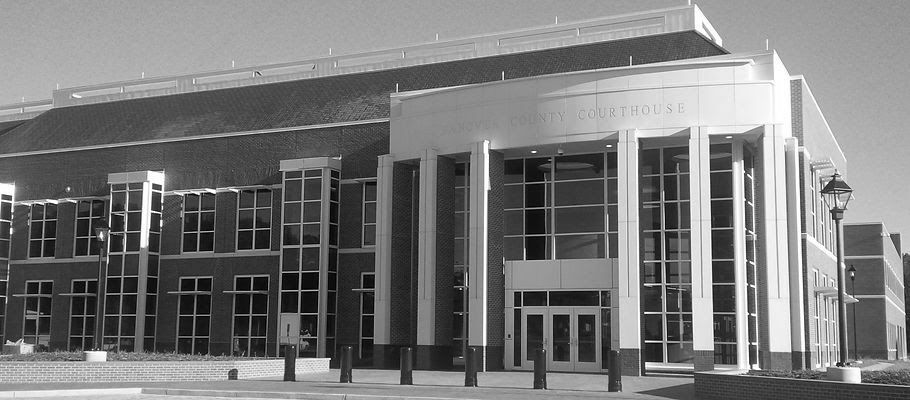 A black and white photo of a large brick building with the word justice on the top