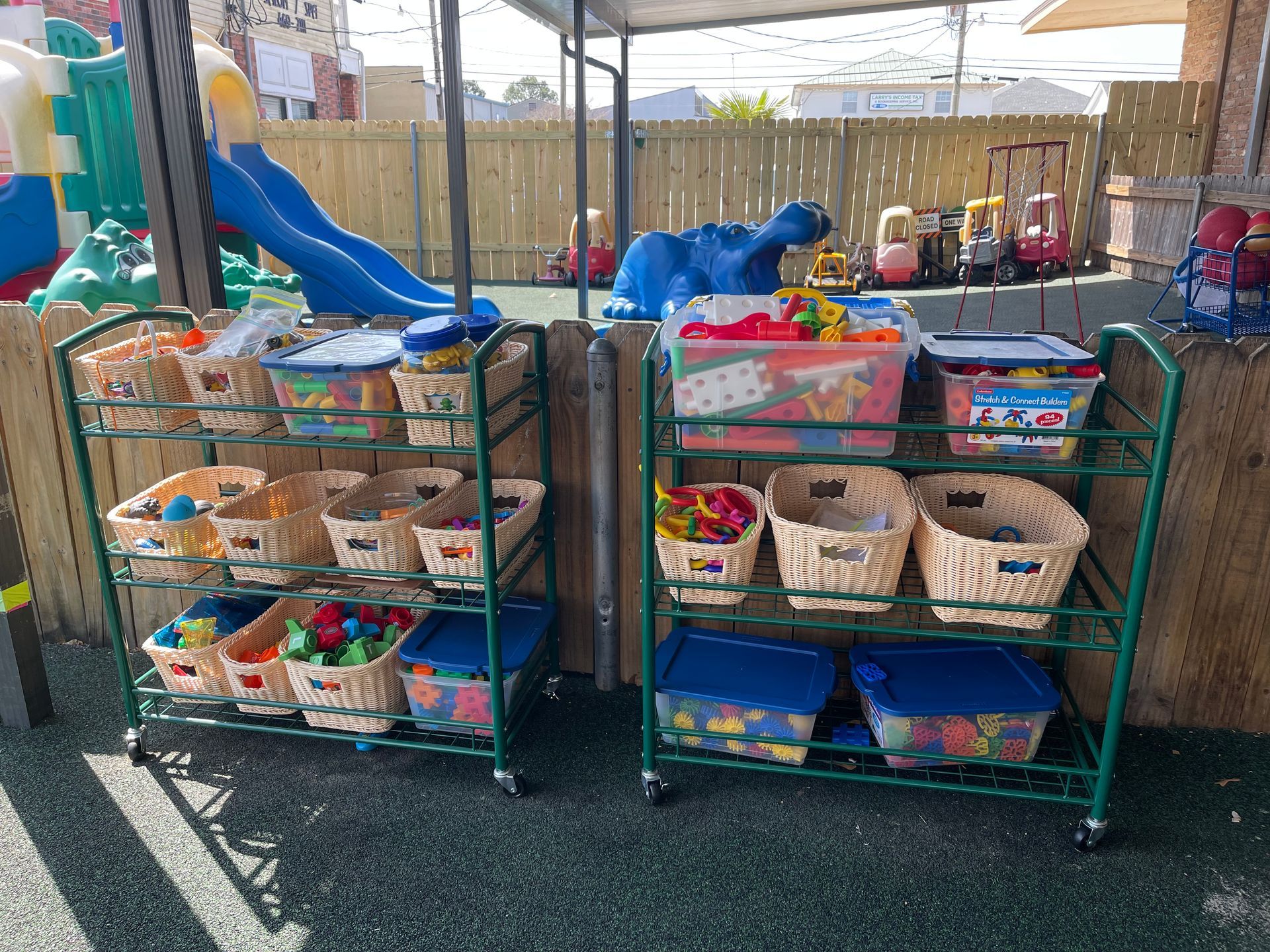 two shelves filled with baskets of toys and a slide in the background .