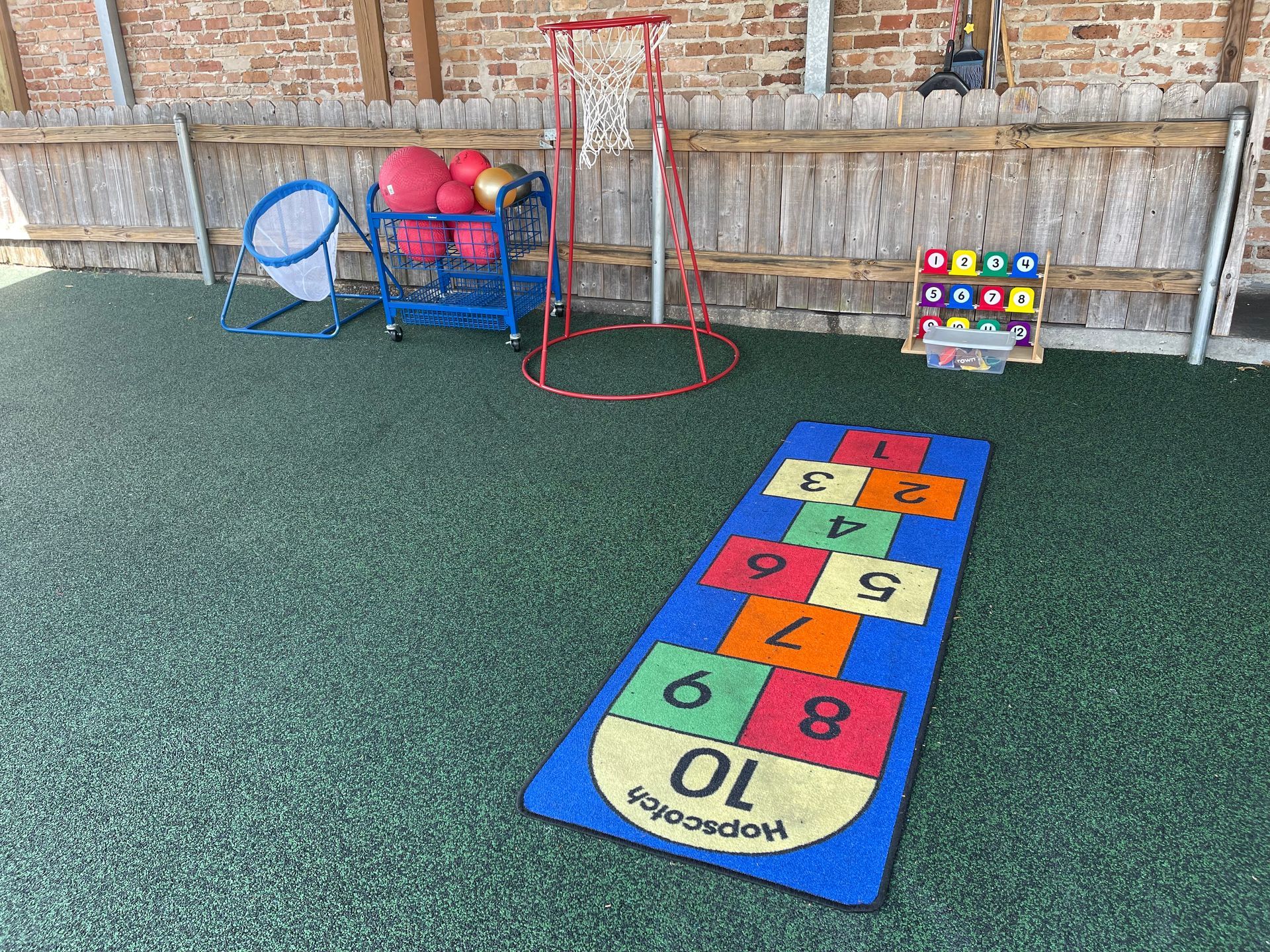 there is a hopscotch mat in the middle of the yard .