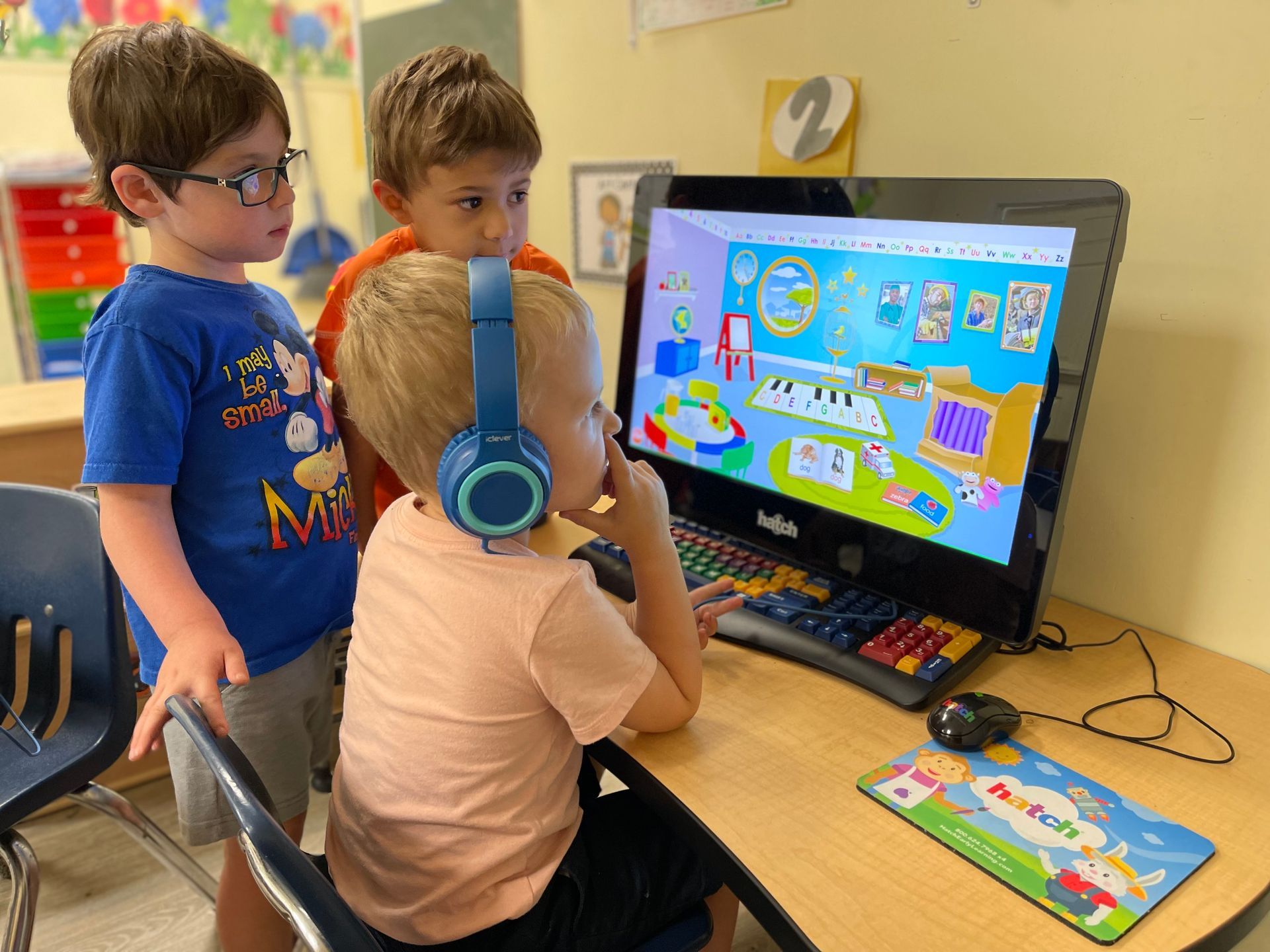 three young boys are playing a game on a computer .
