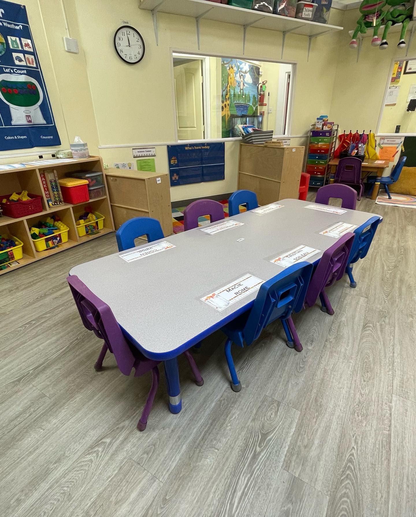 a classroom with tables and chairs and a clock on the wall .