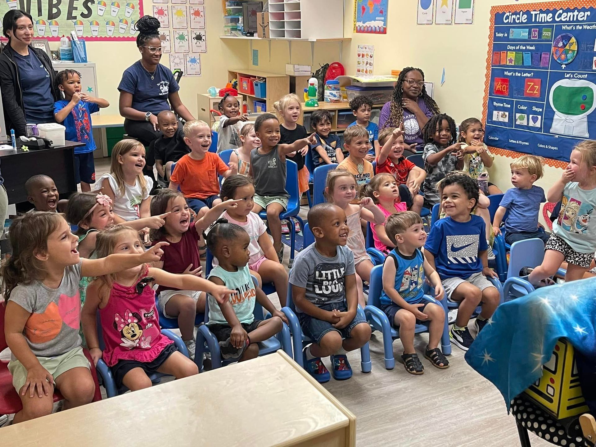 a group of children are sitting in chairs in a classroom .