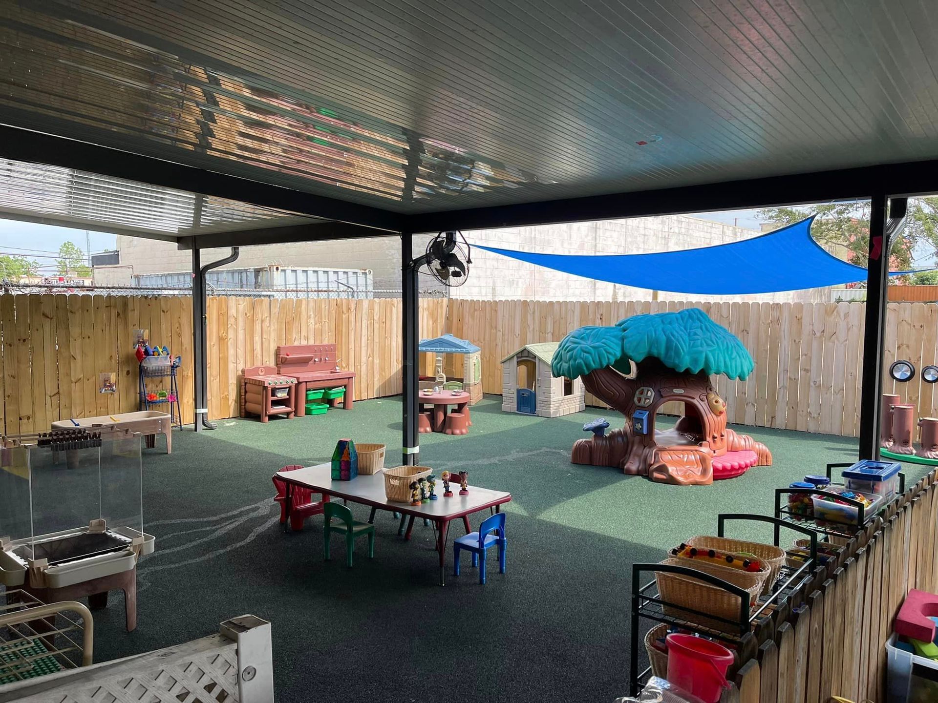 a playground with tables , chairs , and a tree house .