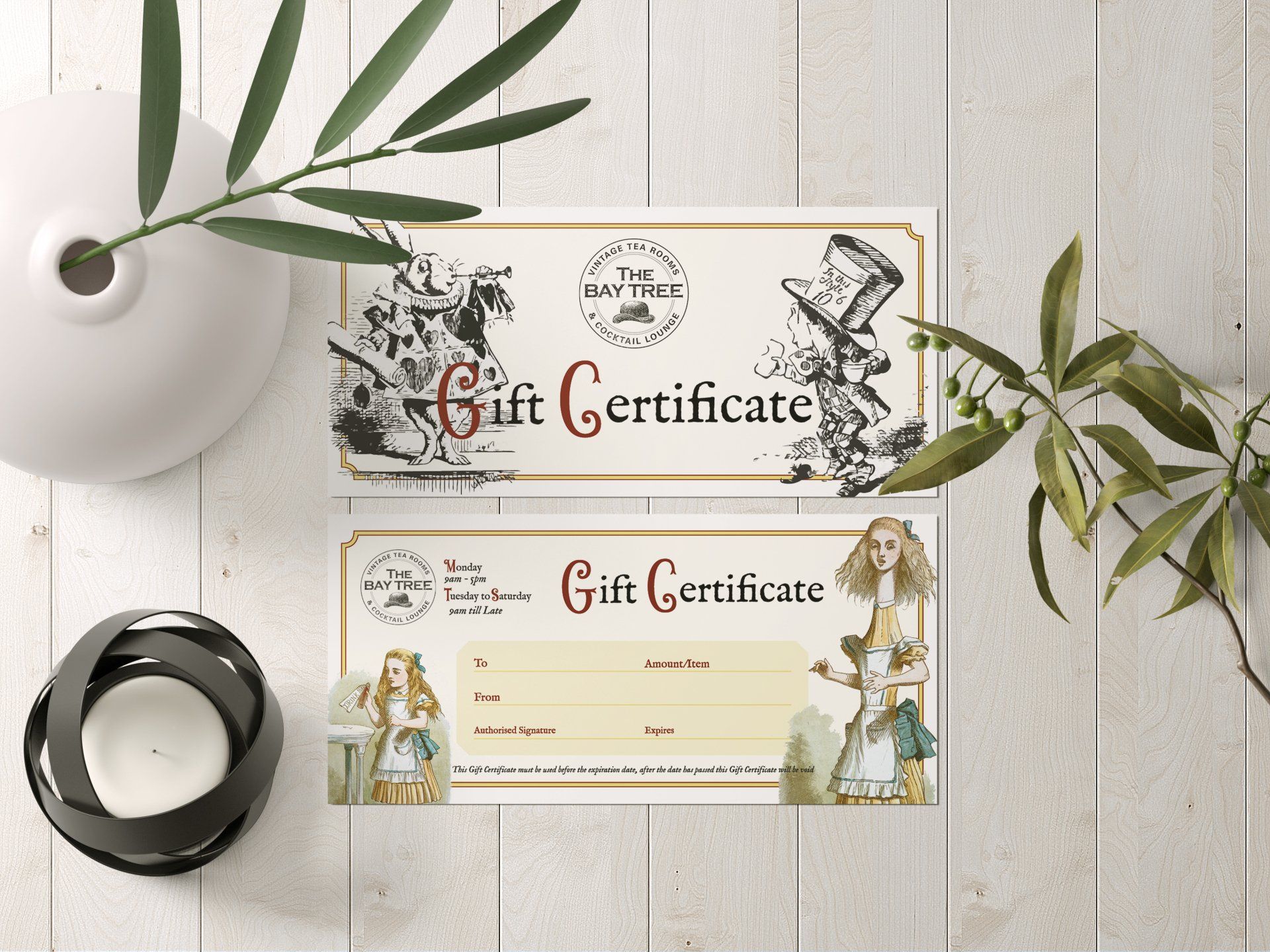 A gift certificate is sitting on a wooden table next to a vase and a candle.