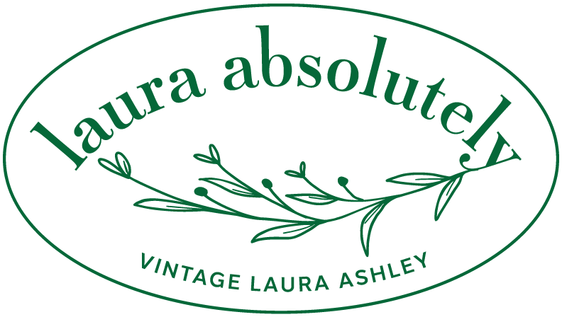 A green logo for laura absolutely vintage laura ashley