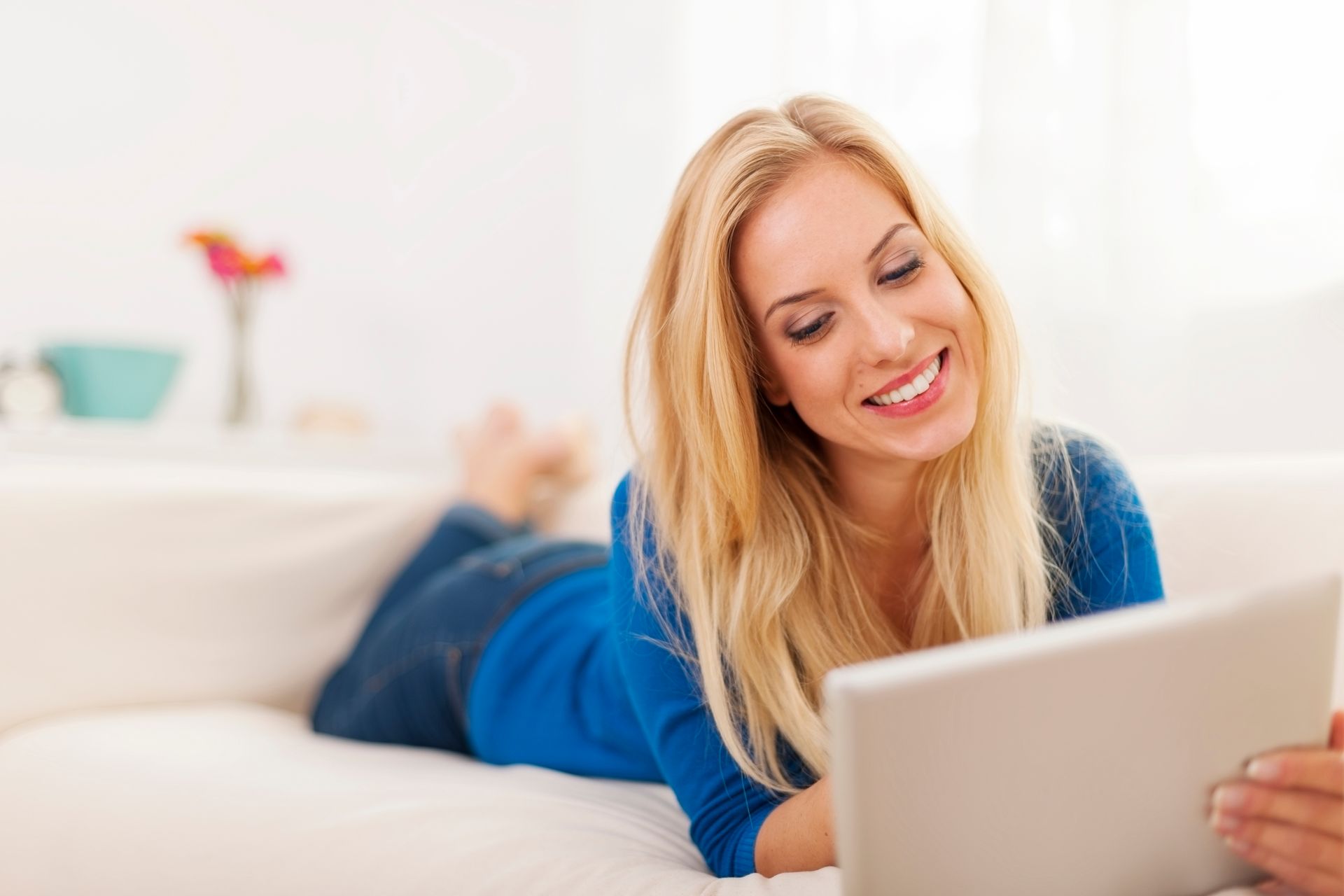 Brand & Flair Website Design  - A woman is laying on a couch using a tablet computer.