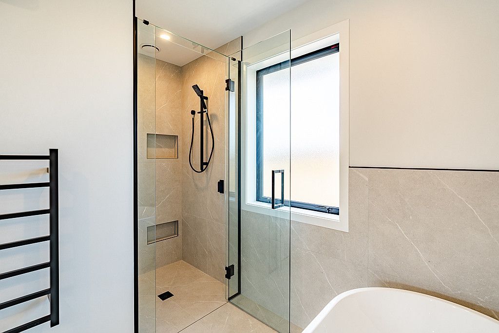 A bathroom with a walk in shower and a bathtub.