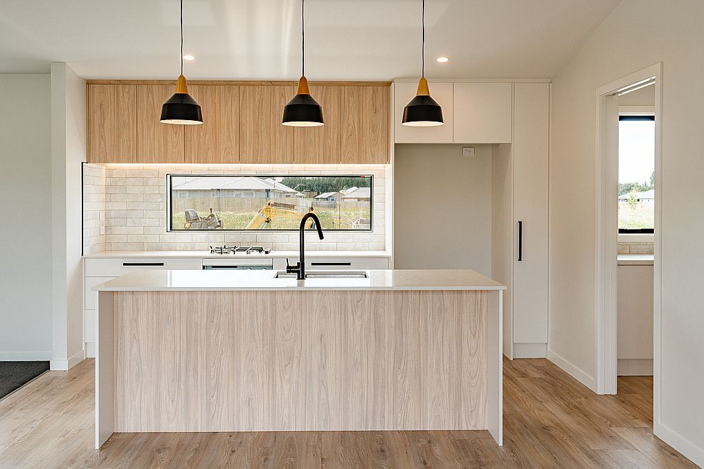 An empty kitchen with a large island in the middle of the room.