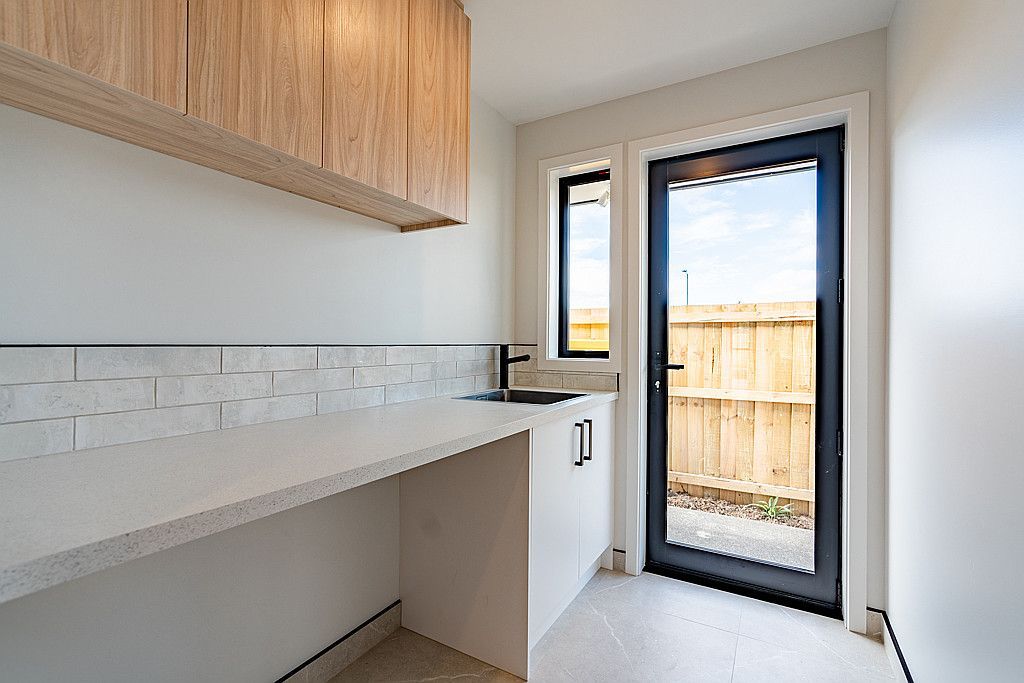 A kitchen with a sink , cabinets , and a sliding glass door.