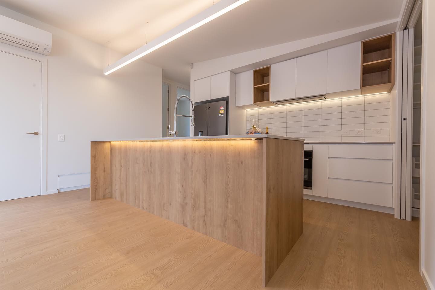 A kitchen with a wooden island and white cabinets.