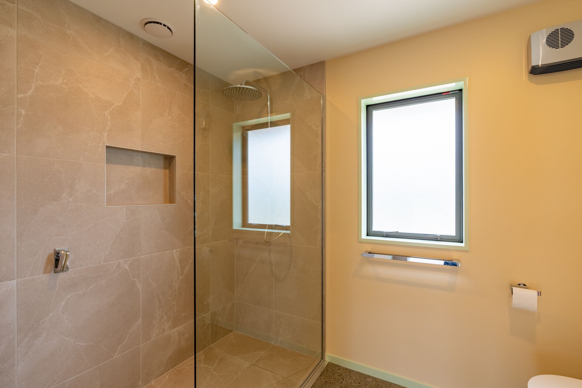 A bathroom with a walk in shower and a toilet.