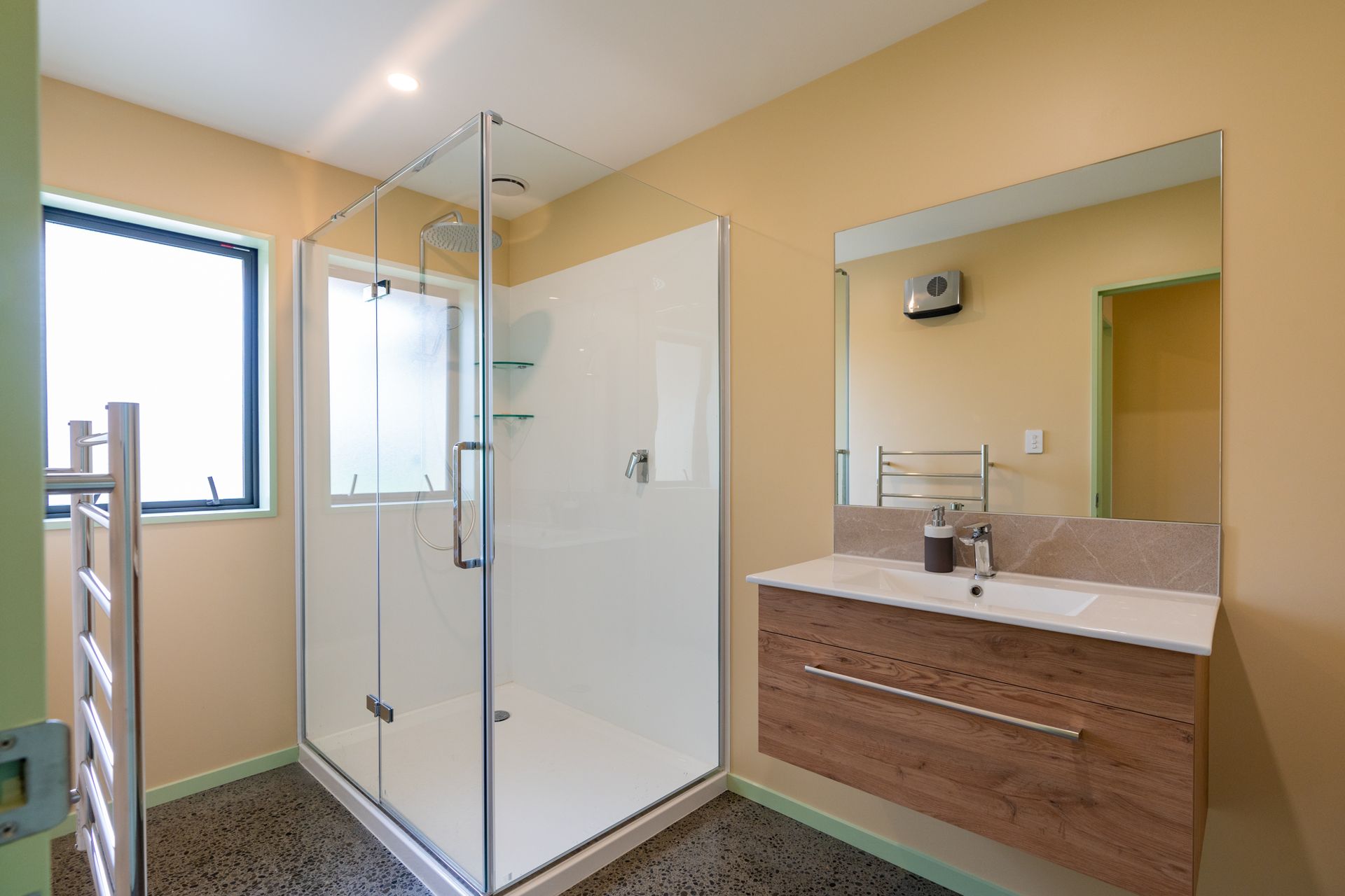 A bathroom with a sink , shower , and mirror.