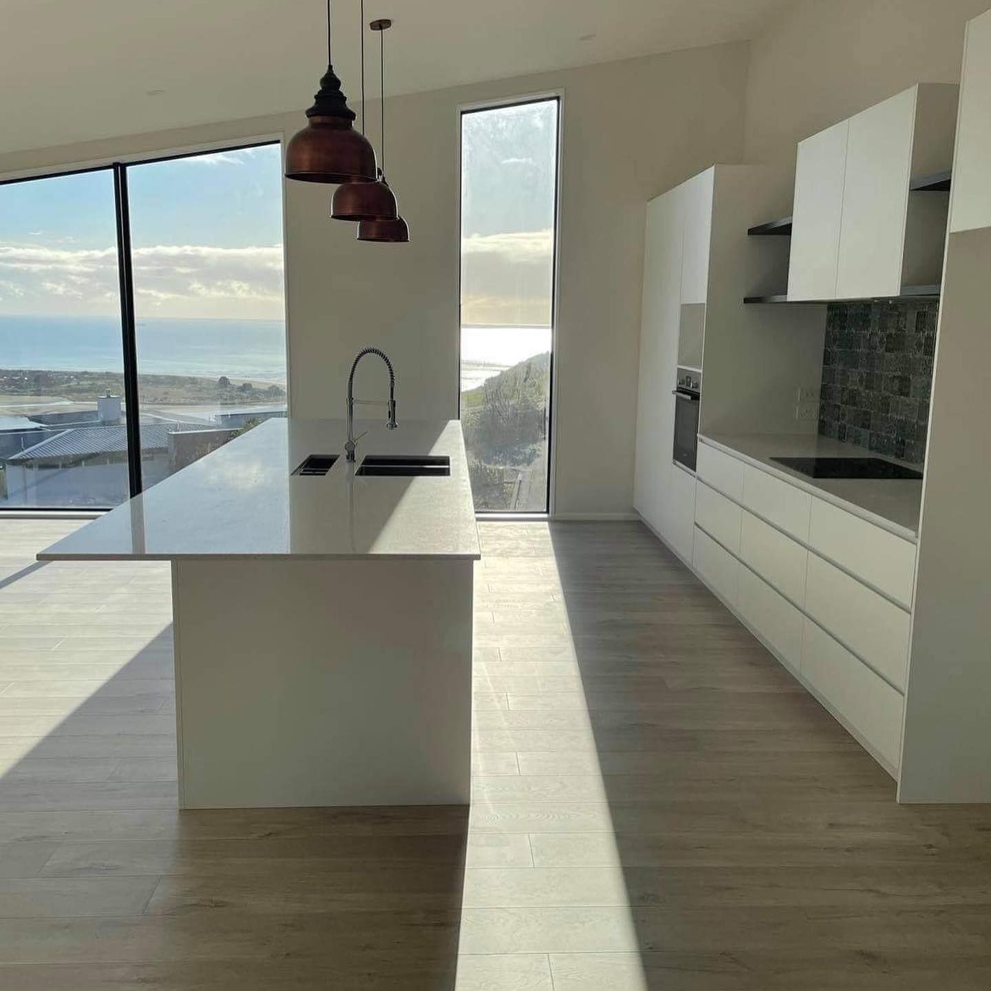 A kitchen with a large island and a large window.