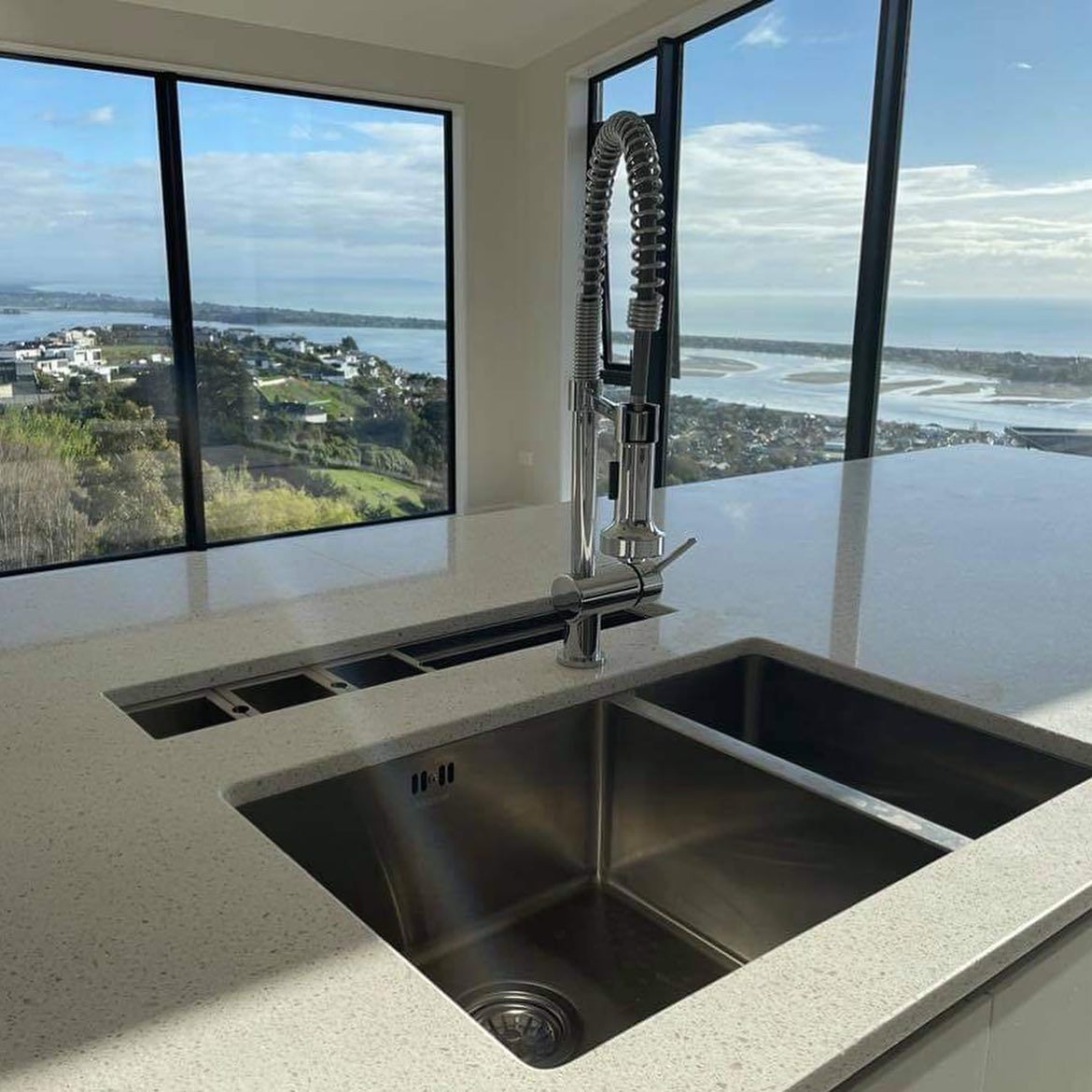 A kitchen sink with a view of the ocean