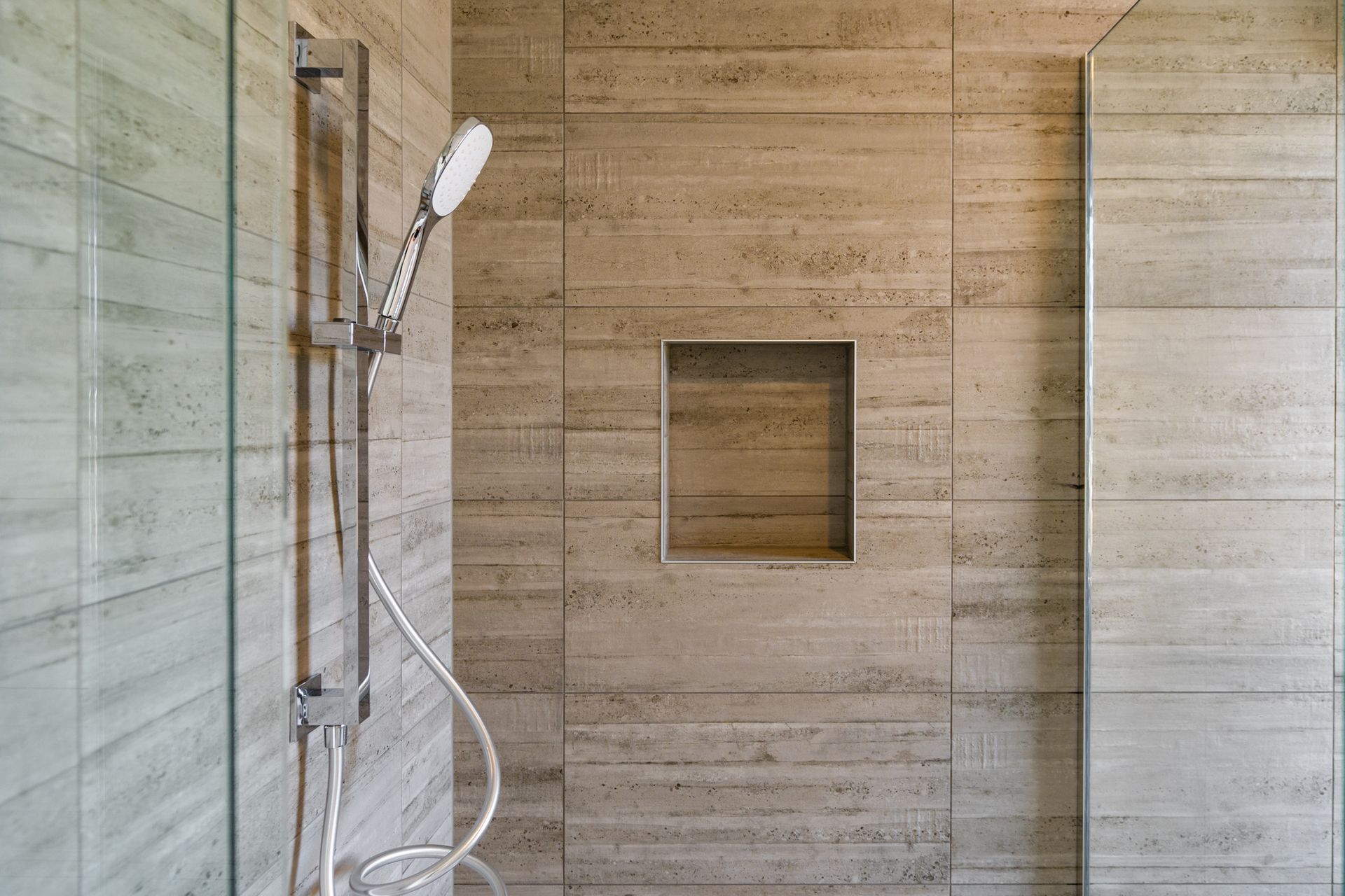 A shower with a shower head and a glass door.
