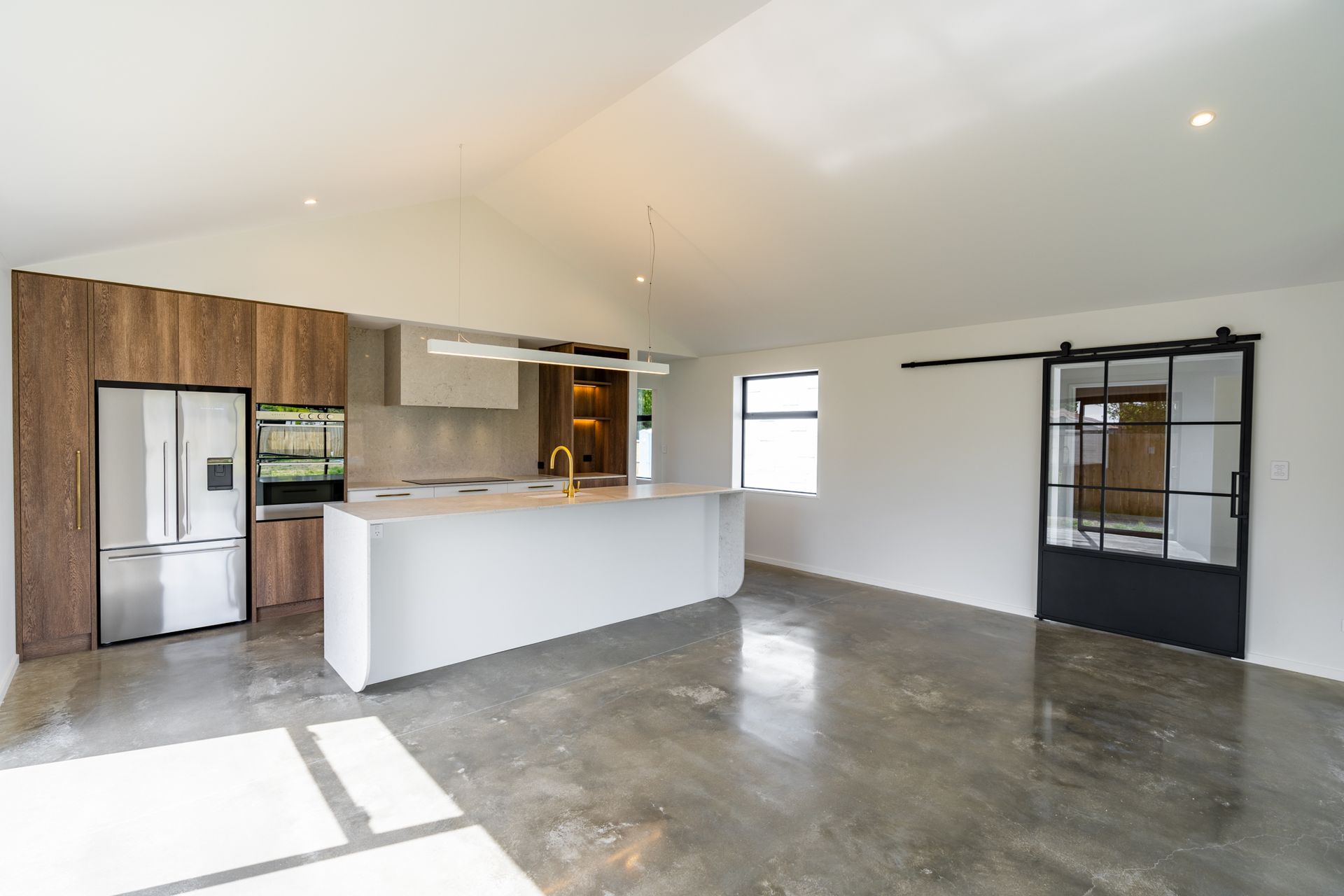 A kitchen with a large island and a sliding barn door.
