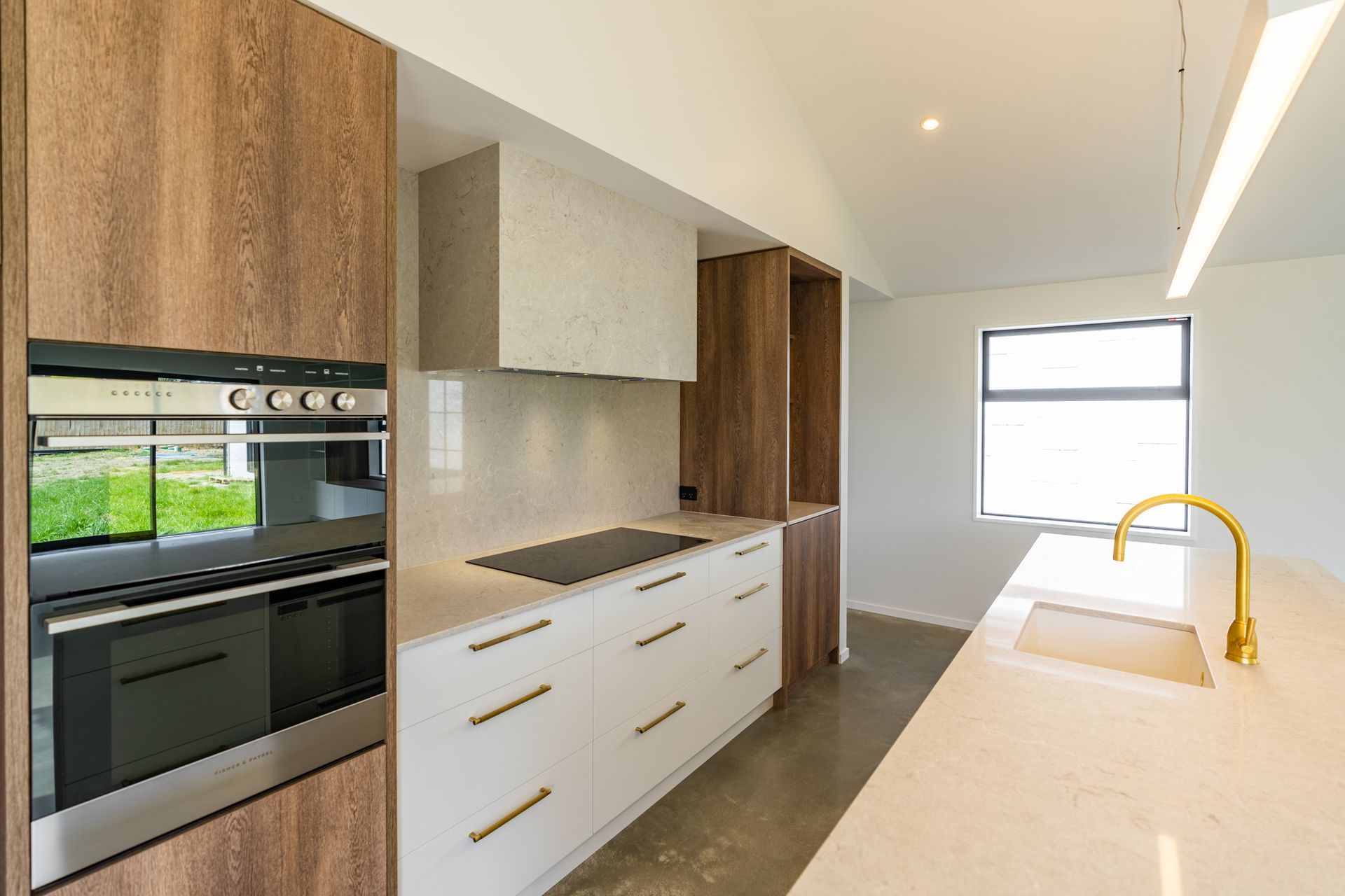 A kitchen with white cabinets , stainless steel appliances , a sink , and a window.