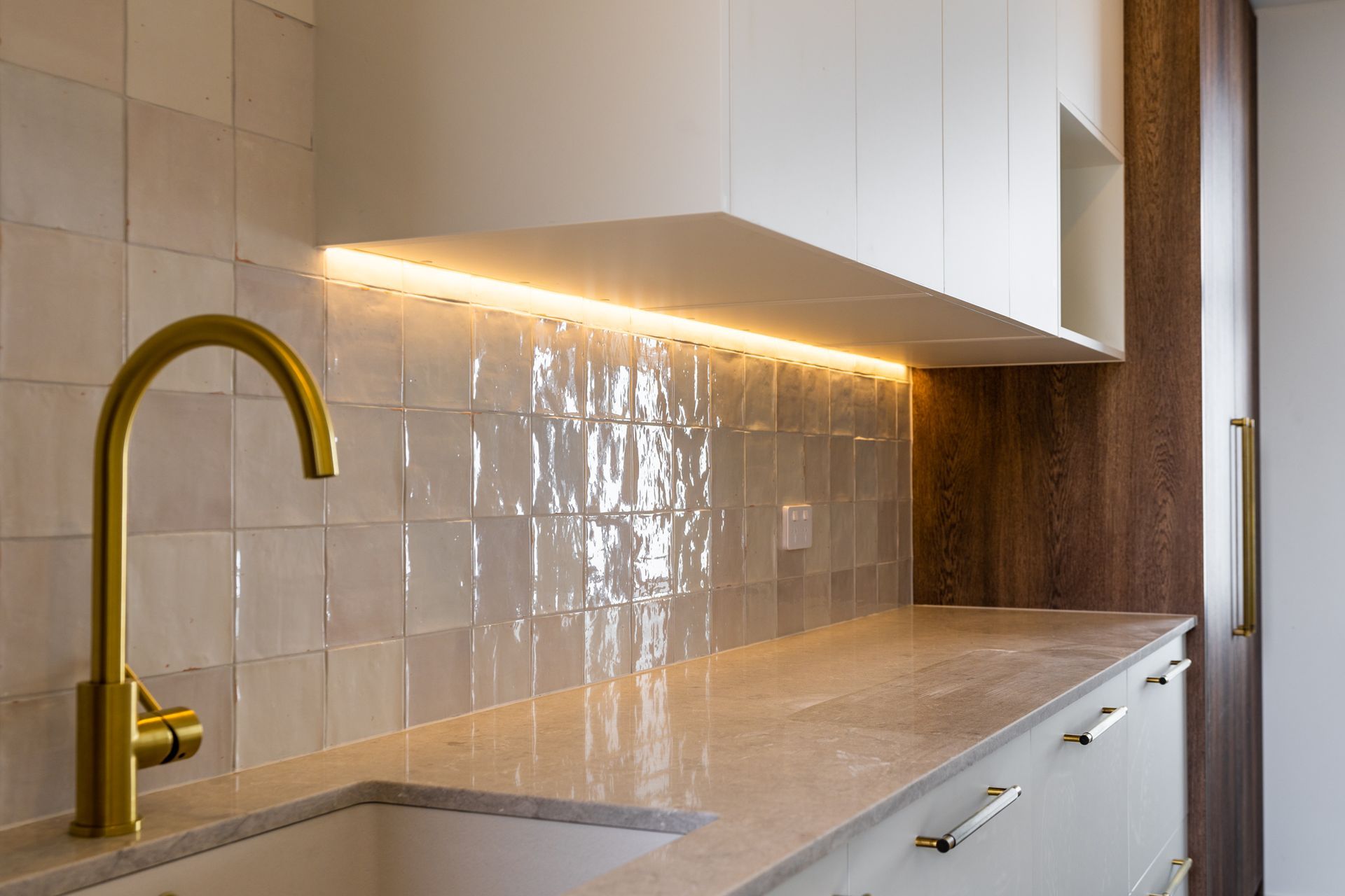 A kitchen with a sink , cabinets , and a faucet.