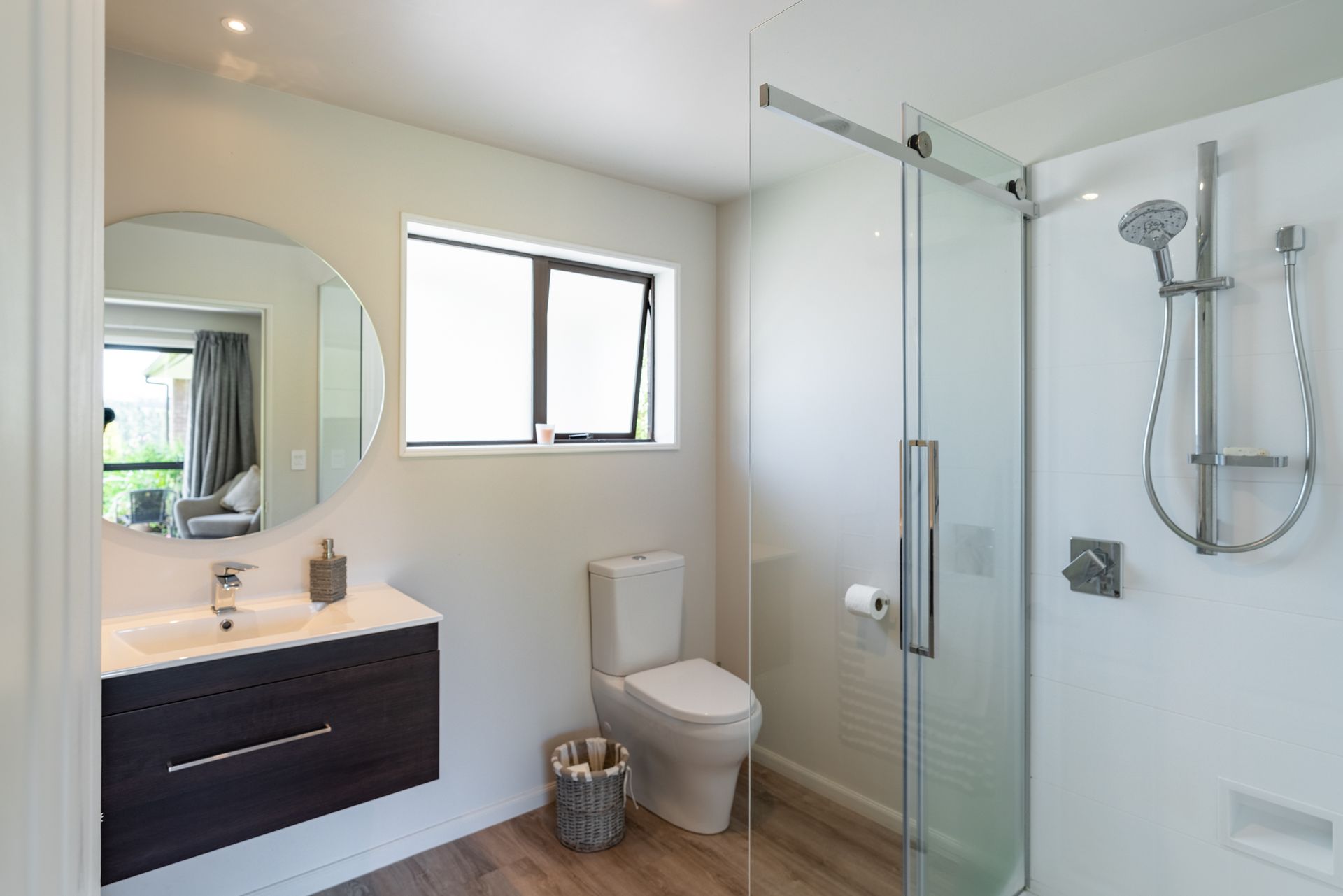 A bathroom with a toilet , sink and shower.