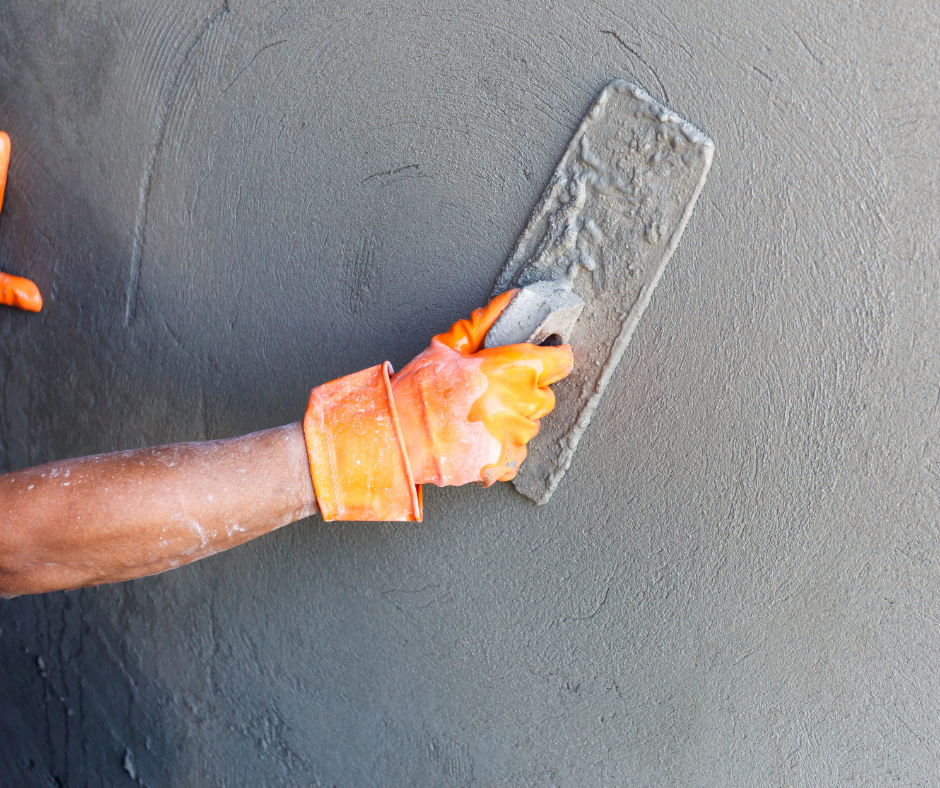 A person is plastering a wall with a trowel.