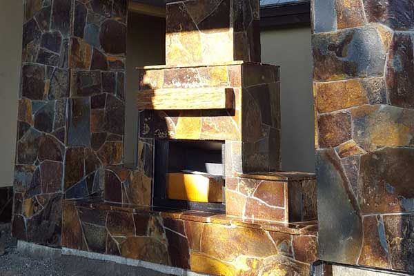 A stone wall with a fireplace in the middle of it