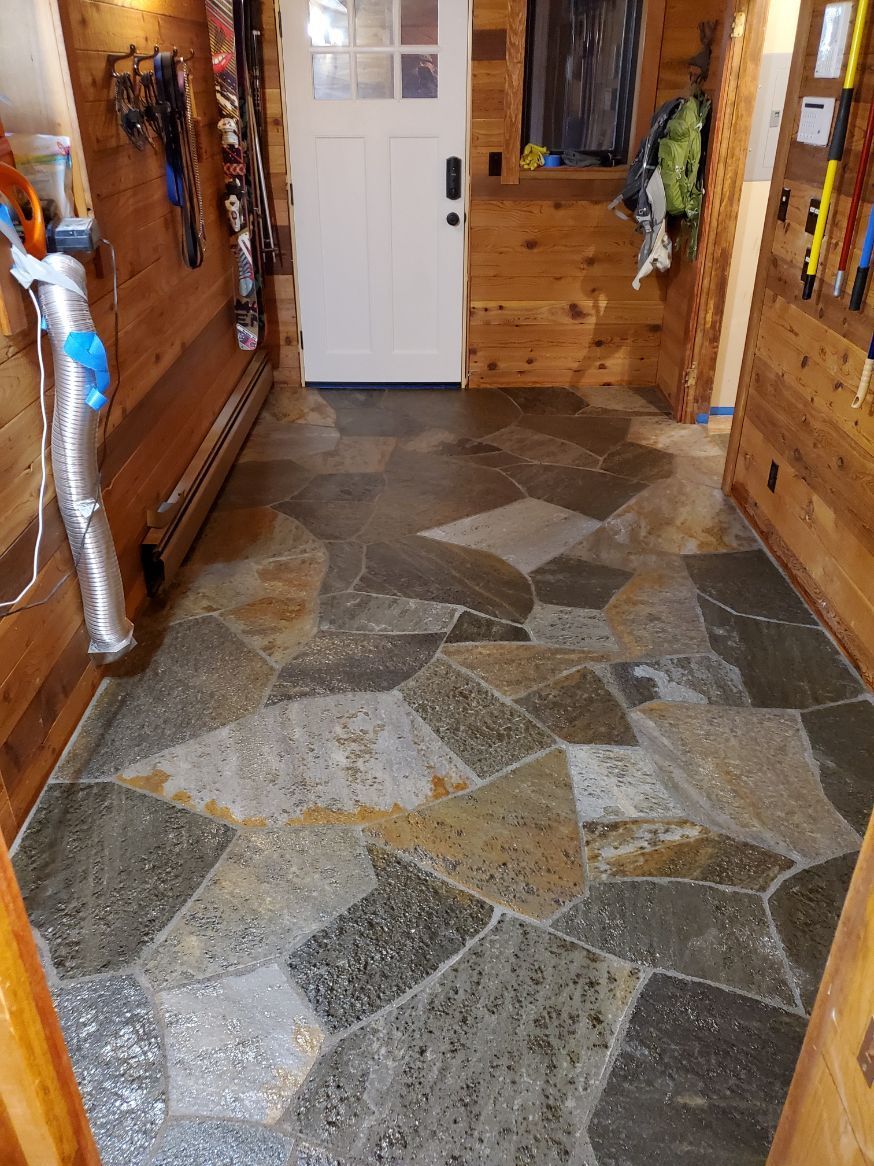 A hallway with a stone floor and wooden walls