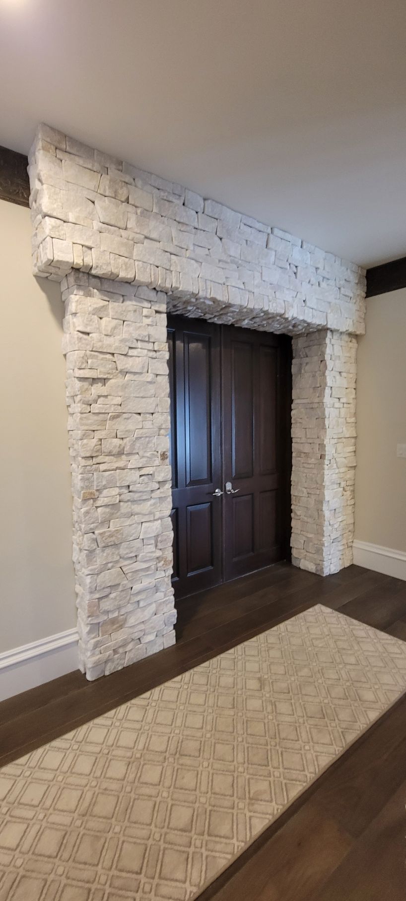 A hallway with a stone wall and a wooden door