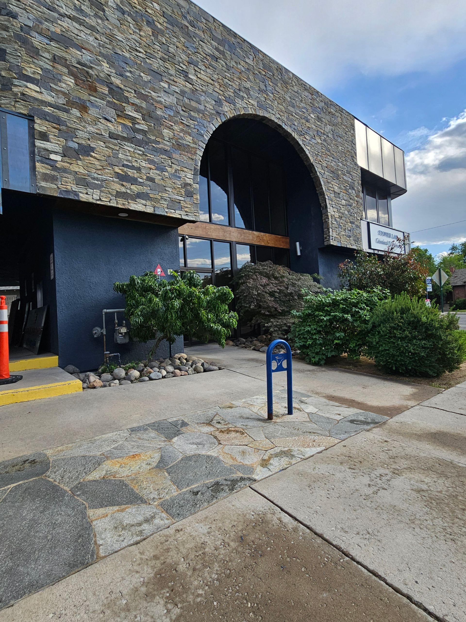 A large stone building with a blue sign in front of it.