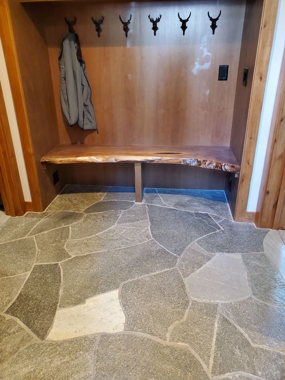 A hallway with a wooden bench and a stone floor