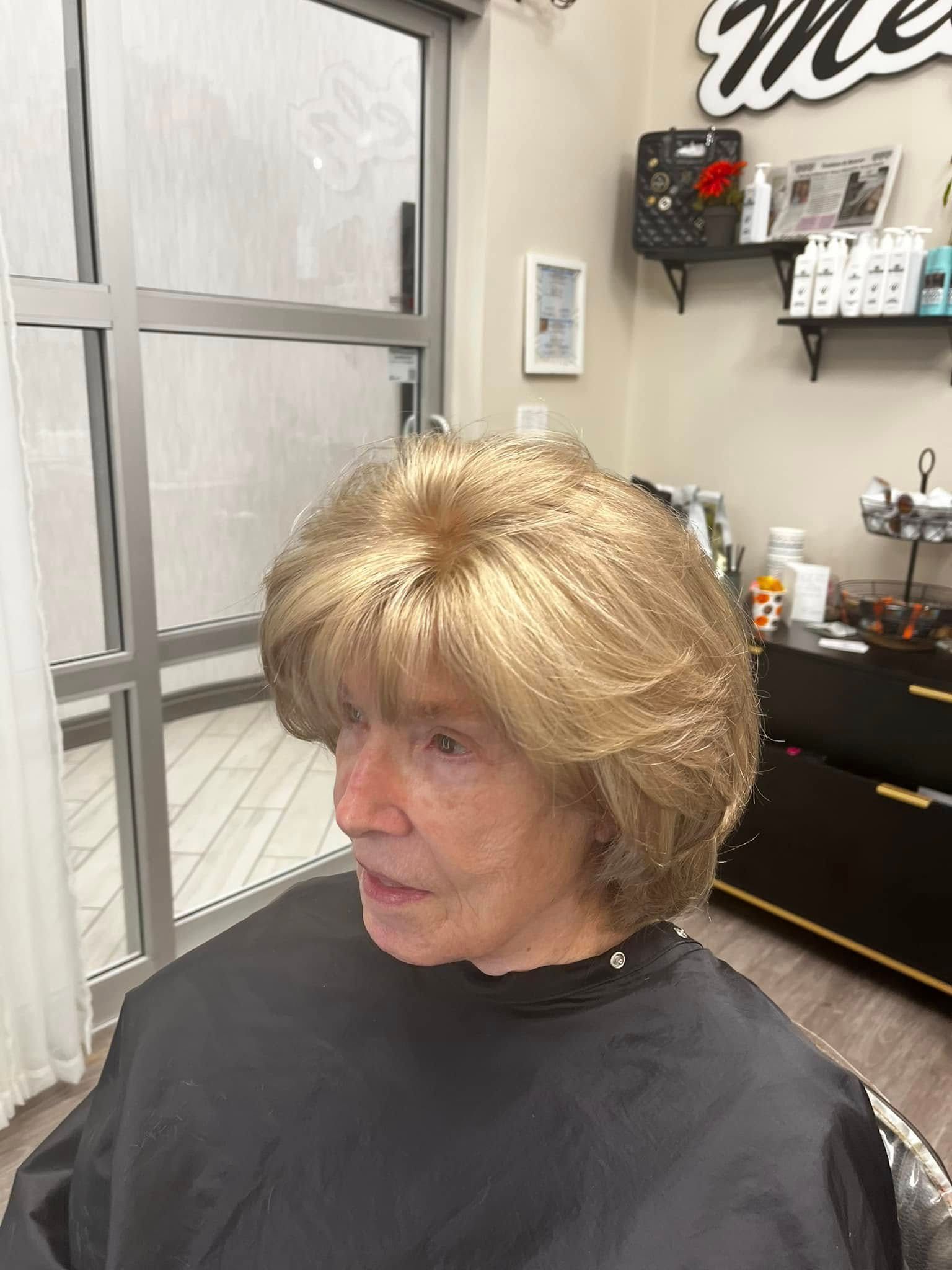 Hands attaching a hair topper with a clip to a person's head, adding volume to brown hair.