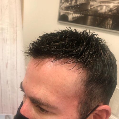 Hands attaching a hair topper with a clip to a person's head, adding volume to brown hair.