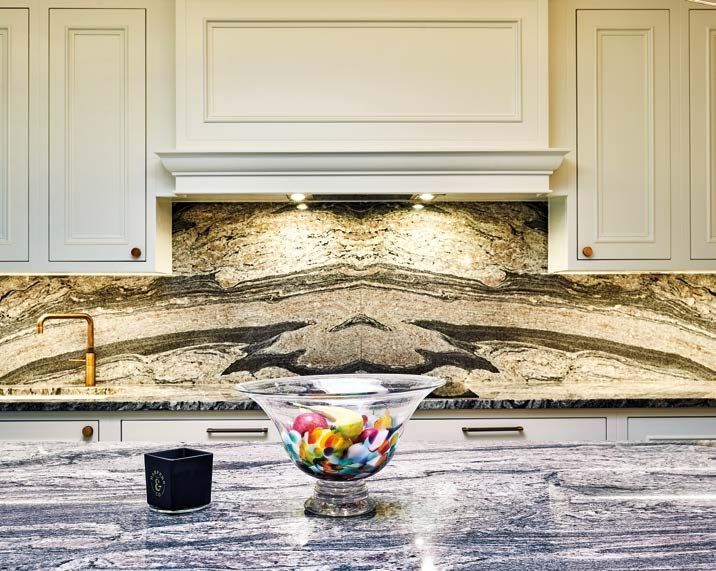 There is a bowl of fruit on the counter in the kitchen.