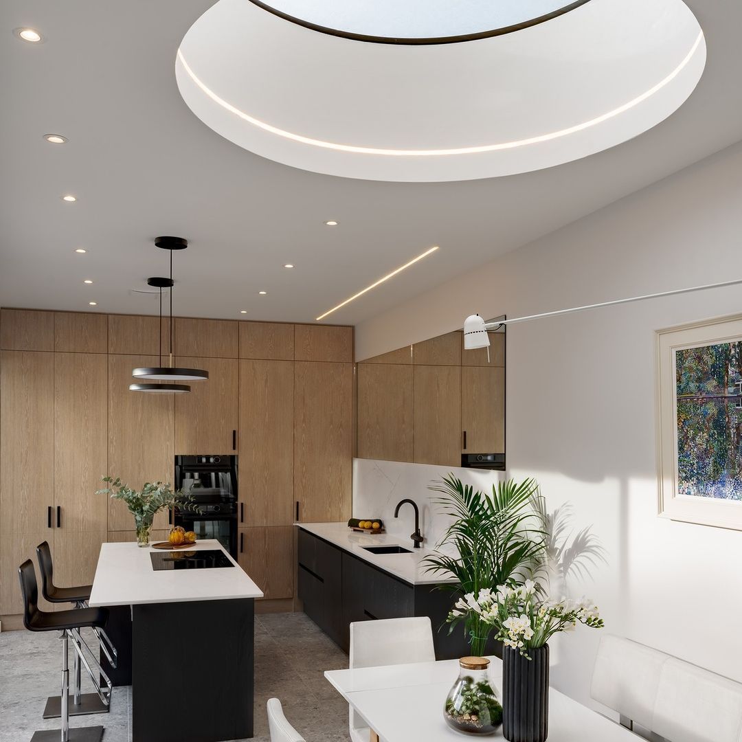 A kitchen with a skylight and a table and chairs