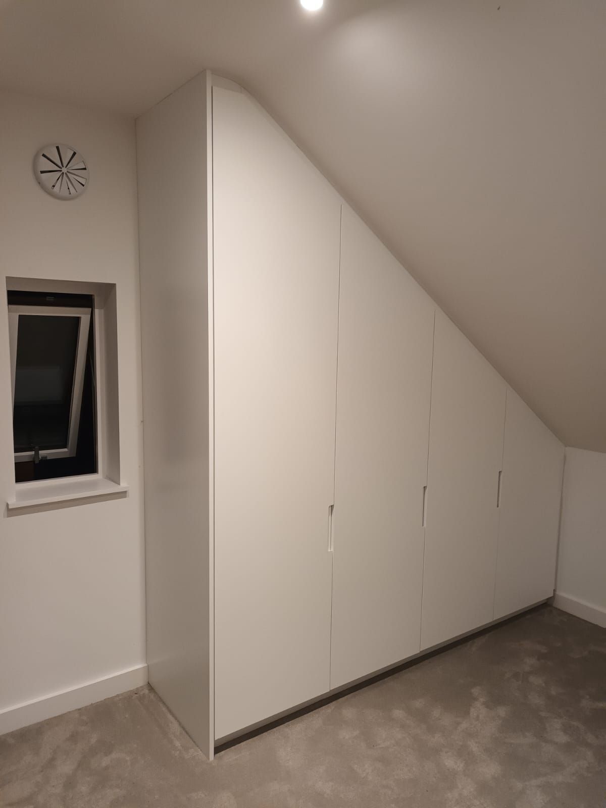 There is a clock on the wall above the window in the room.