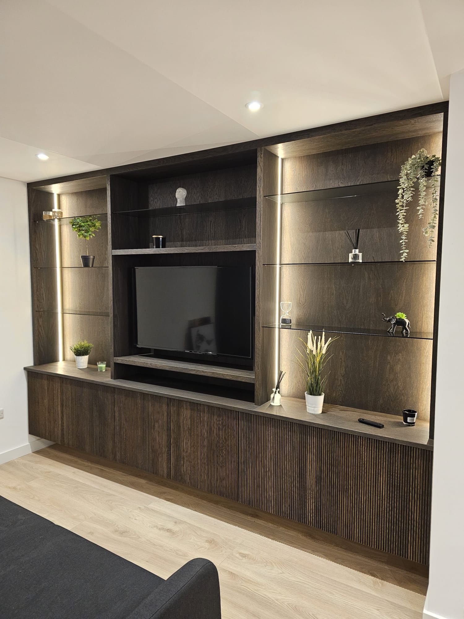 A living room with a large entertainment center and a flat screen tv.