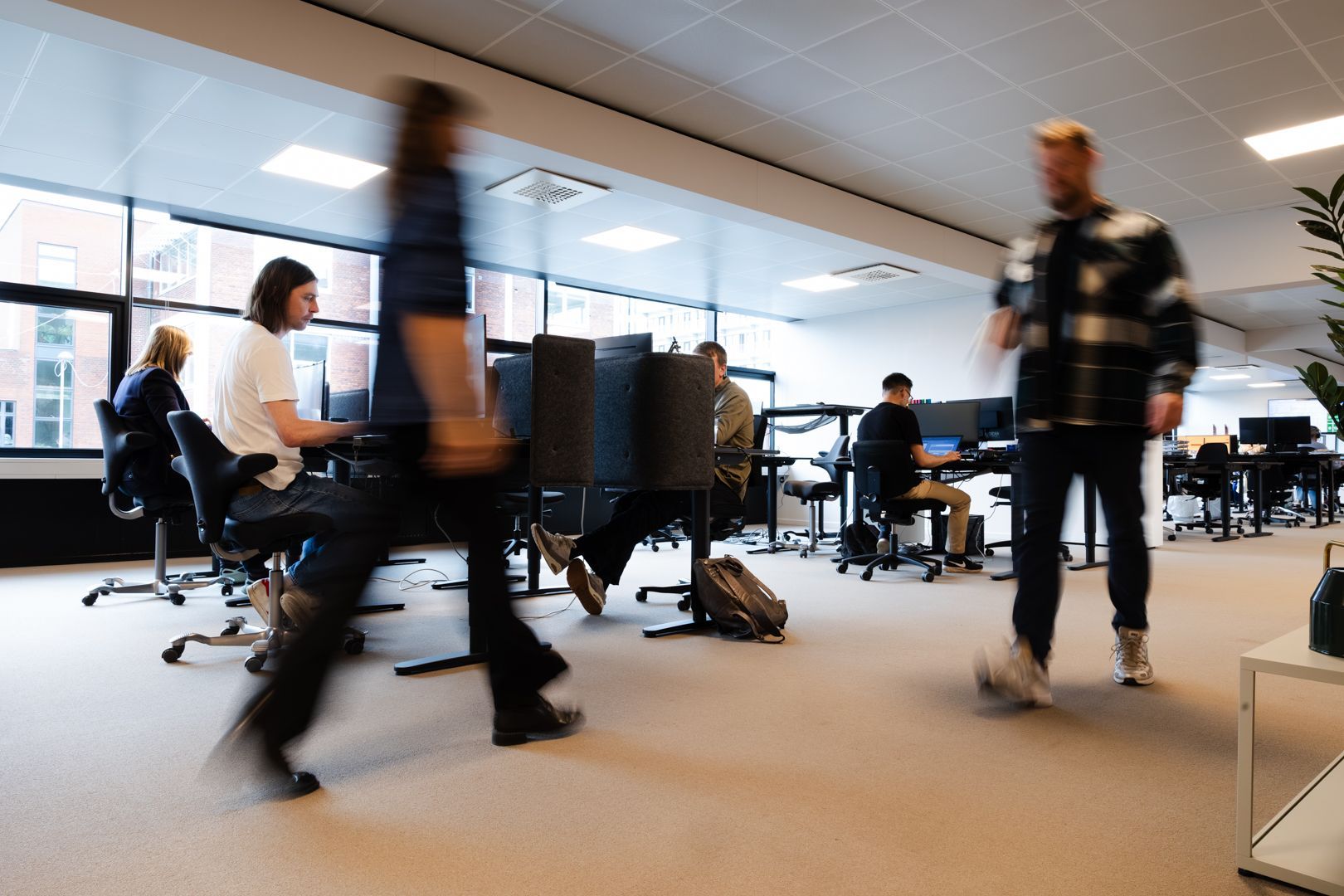 Et sløret billede af en gruppe mennesker, der går på et kontor.