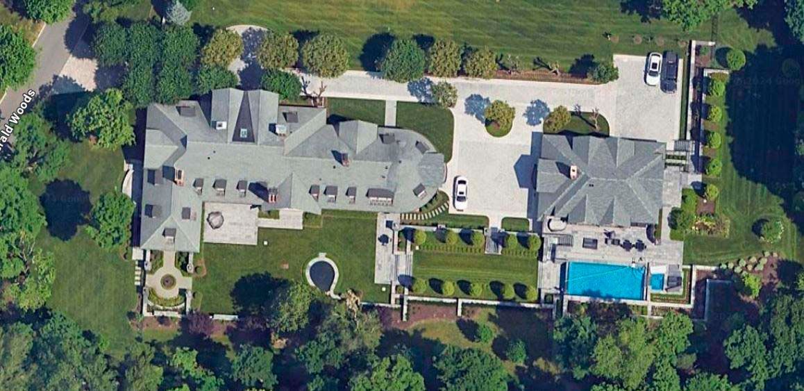 Aerial view of a large estate with a main house, pool, and well-manicured grounds.