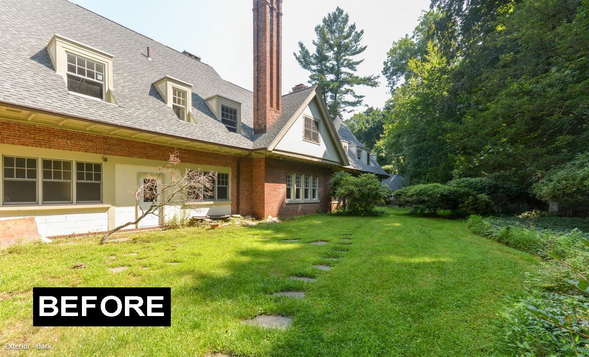 Side view of a house with a brick chimney and a green lawn. 