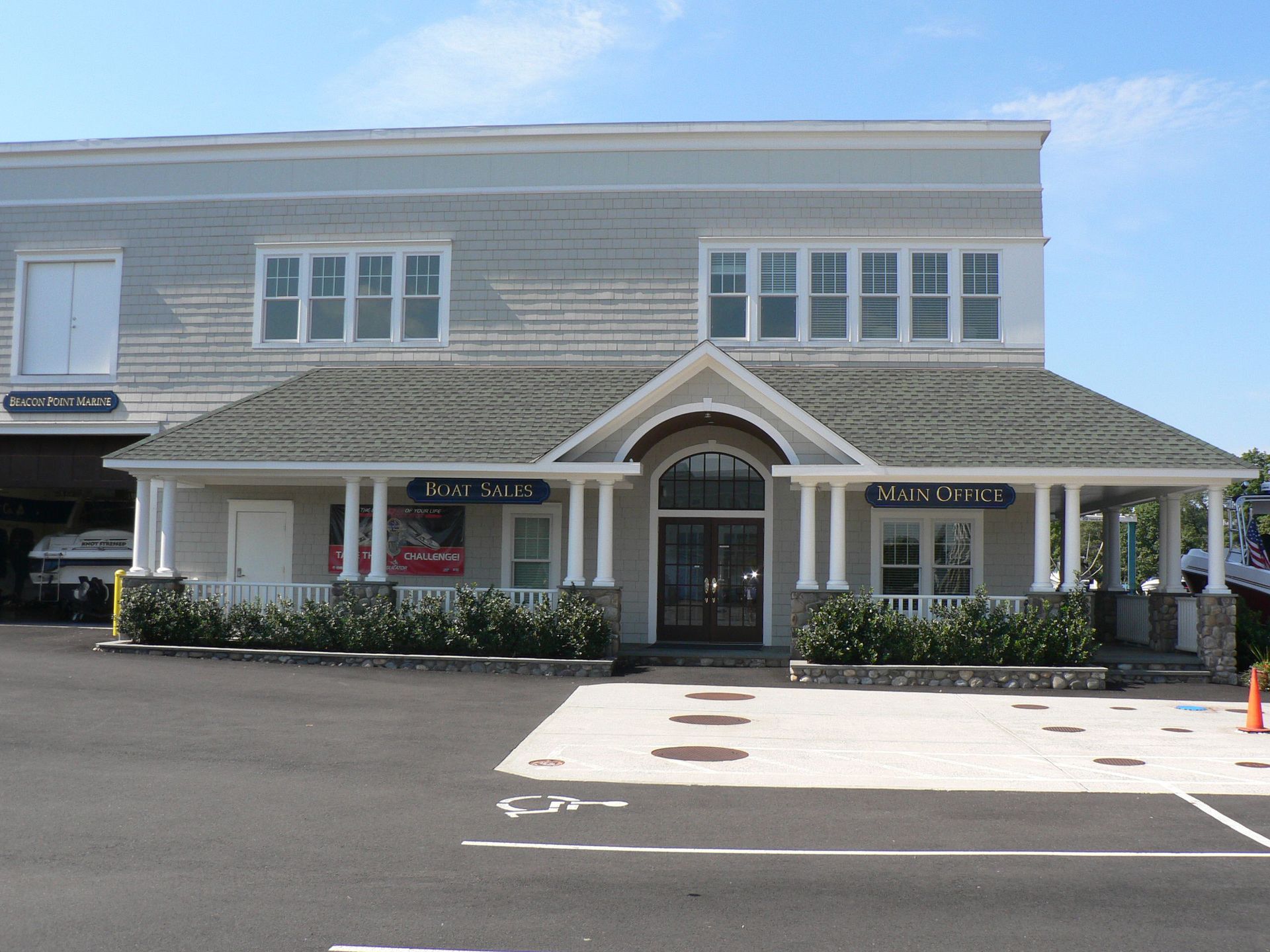 Two-story commercial building with light gray siding and a covered porch.