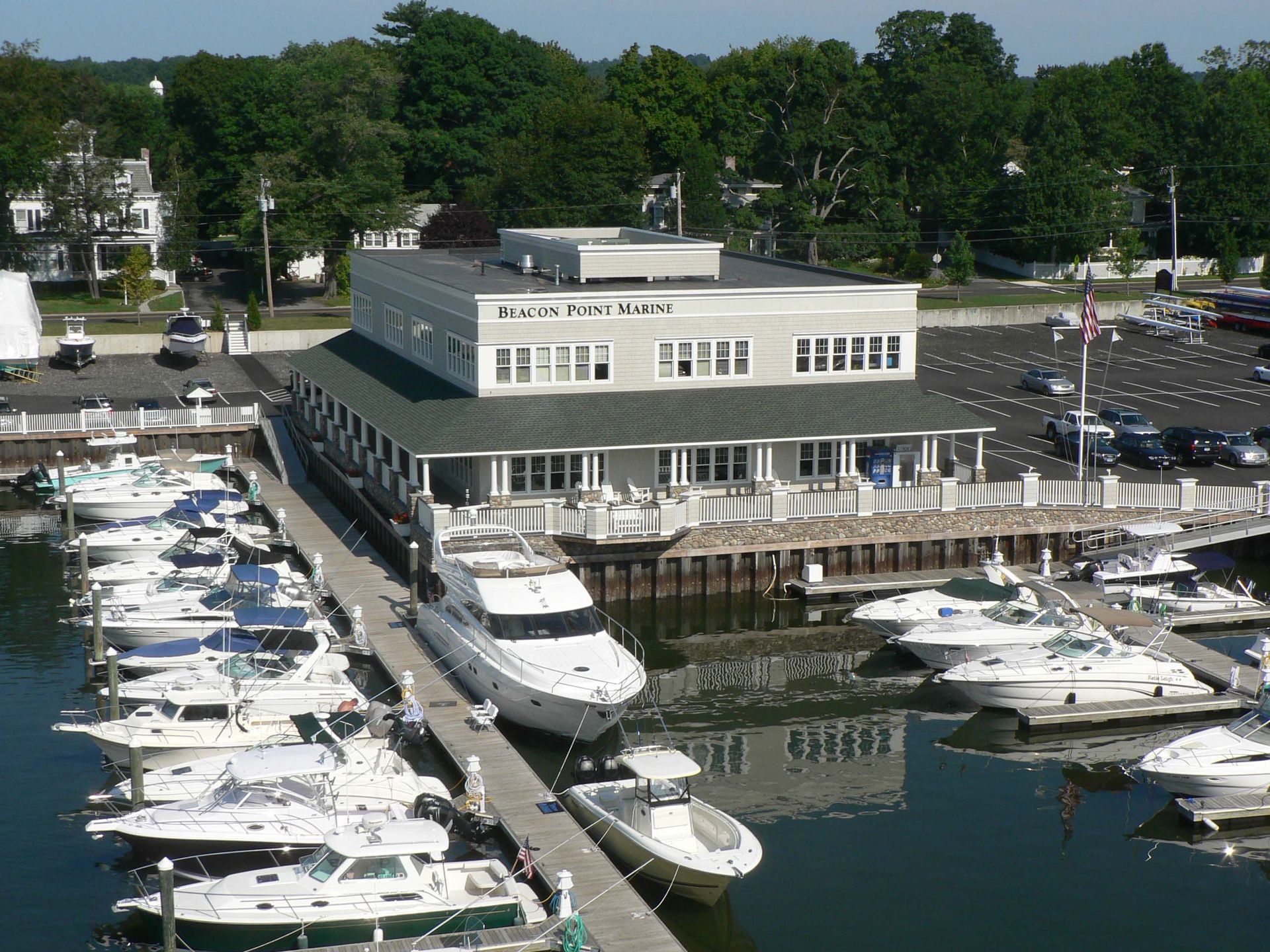 Boats docked at a marina; a two-story gray building with 