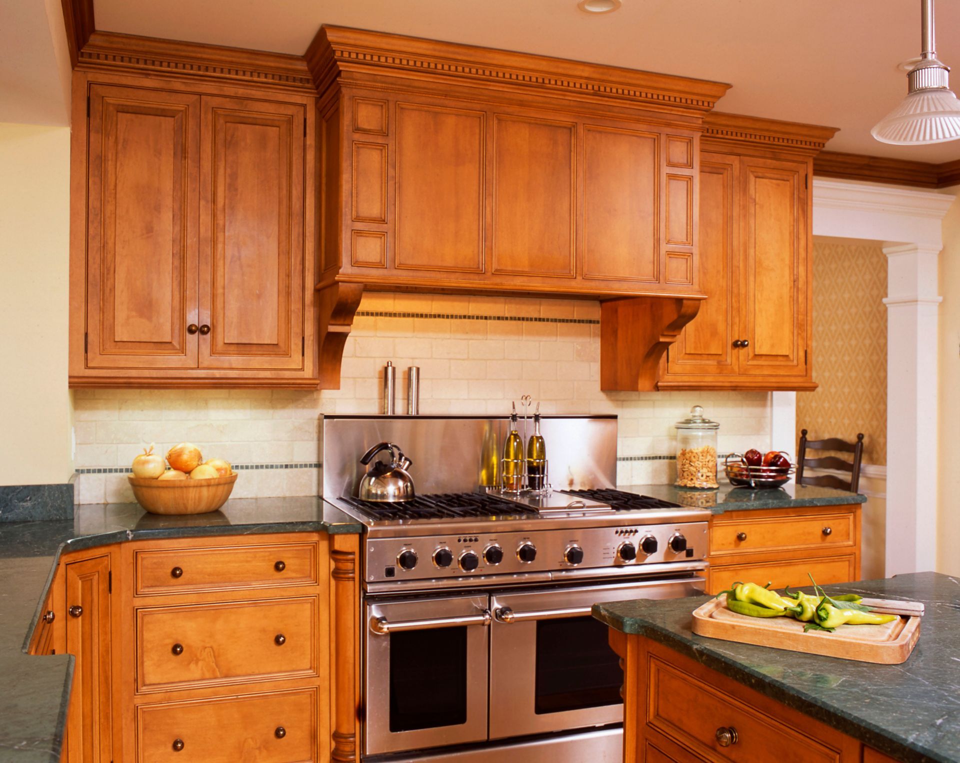 Kitchen with wood cabinets, stainless steel stove, and green countertops.